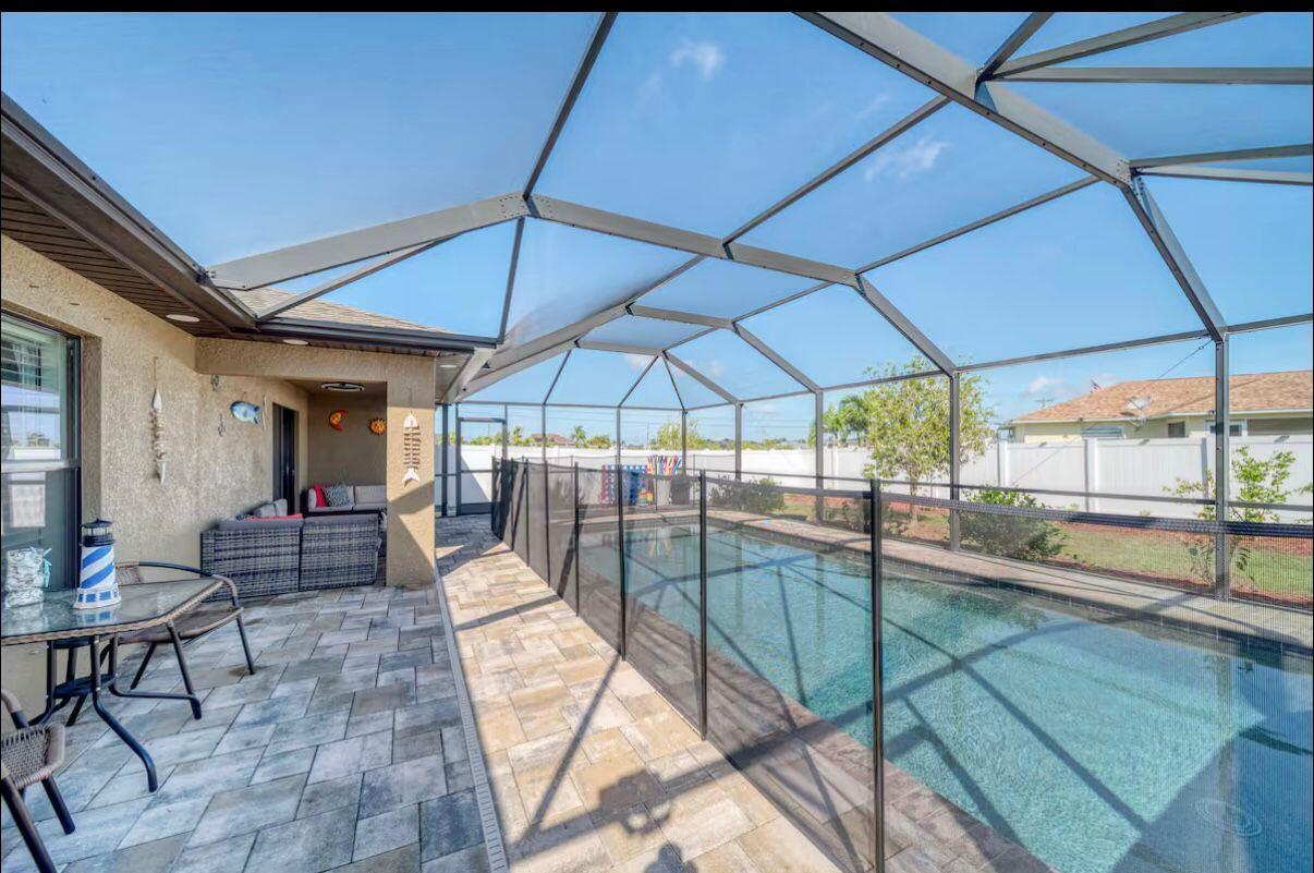 Discover this charming single-family home built in 2018, perfectly situated in desirable Southwest Cape Coral. Offering 3 bedrooms, 2 bathrooms, and 1,522 square feet of living space, this well-maintained residence features an open and inviting floor plan with stylish finishes throughout. Step inside to a seamless flow from the bright living area into the dining space and a well-appointed kitchen complete with a breakfast bar, kitchen island, and pantry—ideal for everyday living and entertaining. The split-bedroom layout provides privacy, while tile and carpet flooring, ceiling fans, and central air keep the home comfortable year-round. A 2-car attached garage adds convenience and storage.  Outside, enjoy your private Florida oasis with a large in-ground pool and spacious patio area perfect for lounging, grilling, or relaxing in the sun. The fully fenced backyard ensures privacy and is ideal for families, kids, or pets. Additional highlights include a screened porch/lanai, manual shutters, and excellent curb appeal. Located on a generous 0.24-acre lot between Pine Island Road and Veterans Parkway, this home offers easy access to shopping, dining, schools, parks, and all the amenities Cape Coral has to offer. No HOA fees make it even more appealing. Whether you're looking for a move-in-ready home or a relaxing retreat, this 2018-built gem is ready for you. Schedule your private showing today!