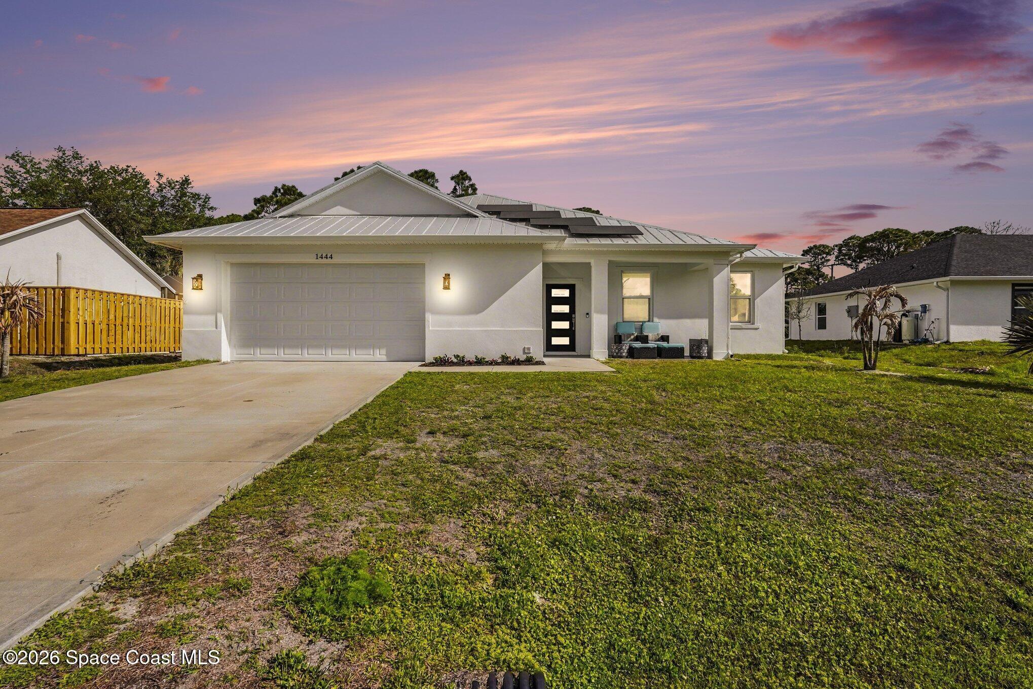 Built in 2022, this custom home offers the perfect blend of luxury, functionality, and energy efficiency. The thoughtfully designed floor plan features a versatile flex room ideal for a home office, guest room, or additional bedroom, plus a convenient half bath. An oversized garage connects directly to a spacious mudroom and laundry area for everyday convenience. The heart of the home is the open-concept living space, showcasing soaring 11'4'' ceilings, abundant natural light, a custom kitchen, and a spacious great room perfect for entertaining. The private primary suite features two walk-in closets and a beautifully designed spa-like bathroom. Each additional bedroom includes its own en-suite bath, providing comfort and privacy for family and guests.  Enjoy Florida living year-round from the front and rear covered patios. Additional highlights include a metal roof, impact windows and doors, and solar panels for peace of mind and lower utility costs.