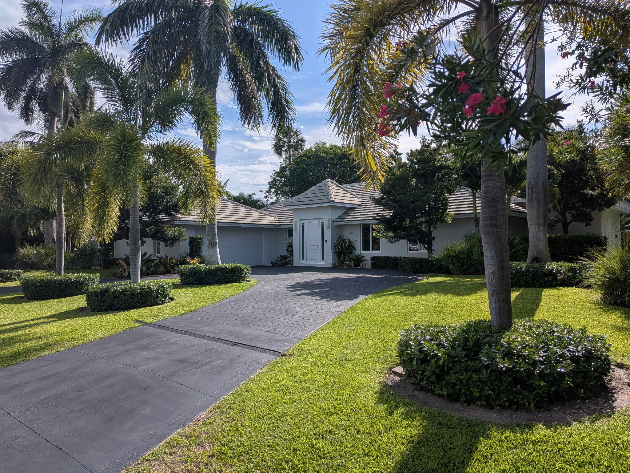 Completely Rebuilt Private Island Retreat — Originally built in 1974 and completely rebuilt in 2021, this turnkey modern coastal residence is tucked within one of Hypoluxo Island's most private enclaves just 15 minutes from Worth Avenue. Featuring soaring ceilings, skylights, expansive sliding glass doors, and seamless indoor-outdoor living, the home is filled with natural light and opens to a private pool surrounded by lush tropical landscaping. All three bedrooms are private suites with en suite bathrooms and walk-in closets, offering an exceptionally comfortable layout for both full-time and seasonal living. Thoughtfully updated with warm modern finishes and a refined coastal aesthetic, this sophisticated island retreat offers privacy, tranquility, and effortless access to Palm Beach,  fine dining, golf, marinas, shopping, and beaches.