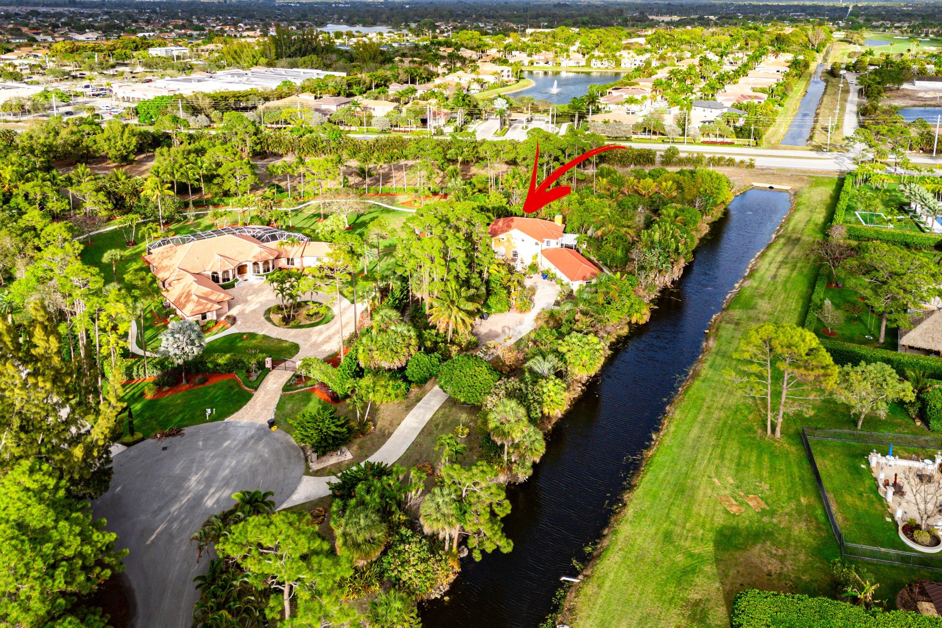 Welcome to this extraordinary, custom-built, estate home nestled in a cul-de-sac on 1.82 acres, located in the prestigious community of St Andrews of Sherbrooke. This community is minutes from the equestrian capital of the world and the epicenter of American polo in Wellington. The winding driveway to the home showcases a myriad of rare and exotic plants and tropical trees. The spacious, multi-level, 3-bed/4-bath home is ideally situated on a private canal-front. It boasts 4,000+ sq ft of living spacewith new porcelain floors on the first floor, and features two primary suites, formal living and dining rooms, multiple living areas, and a wood-burning fireplace.  The kitchen showcases, quartz countertops, marble back splash, SS appliances and opensto a breakfast nook.  The upstairs,  oversized primary suite offers a sitting area, walk-in closets, extra-large bathroom with double sinks, and a separate, large walk-in shower.  The loft includes a wet bar and can easily be converted into a fourth bedroom or office. Major updates include impact windows and doors (2019); exterior living spaces completed in 2020; new impact-rated hurricane doors on a 3-car garage (2023); new roof replacement (2023) and 3 A/C systems throughout. Outdoor highlights a dual irrigation system (well+ canal). Adjacent to the property is NOKOSI, the new Jack Nicklaus championship golf course  - a premier golf and lifestyle destination featuring a Jack Nacklaus-designed course, wellness center and more. The course is currently under construction and is scheduled for preview play in 4th quarter 2026. This is a rare opportunity for you to own a hidden gem of Royal Wall construction, with major updates in one of Palm Beach County's upscale communities.  Now is the time to establishyour residency before home prices increase.