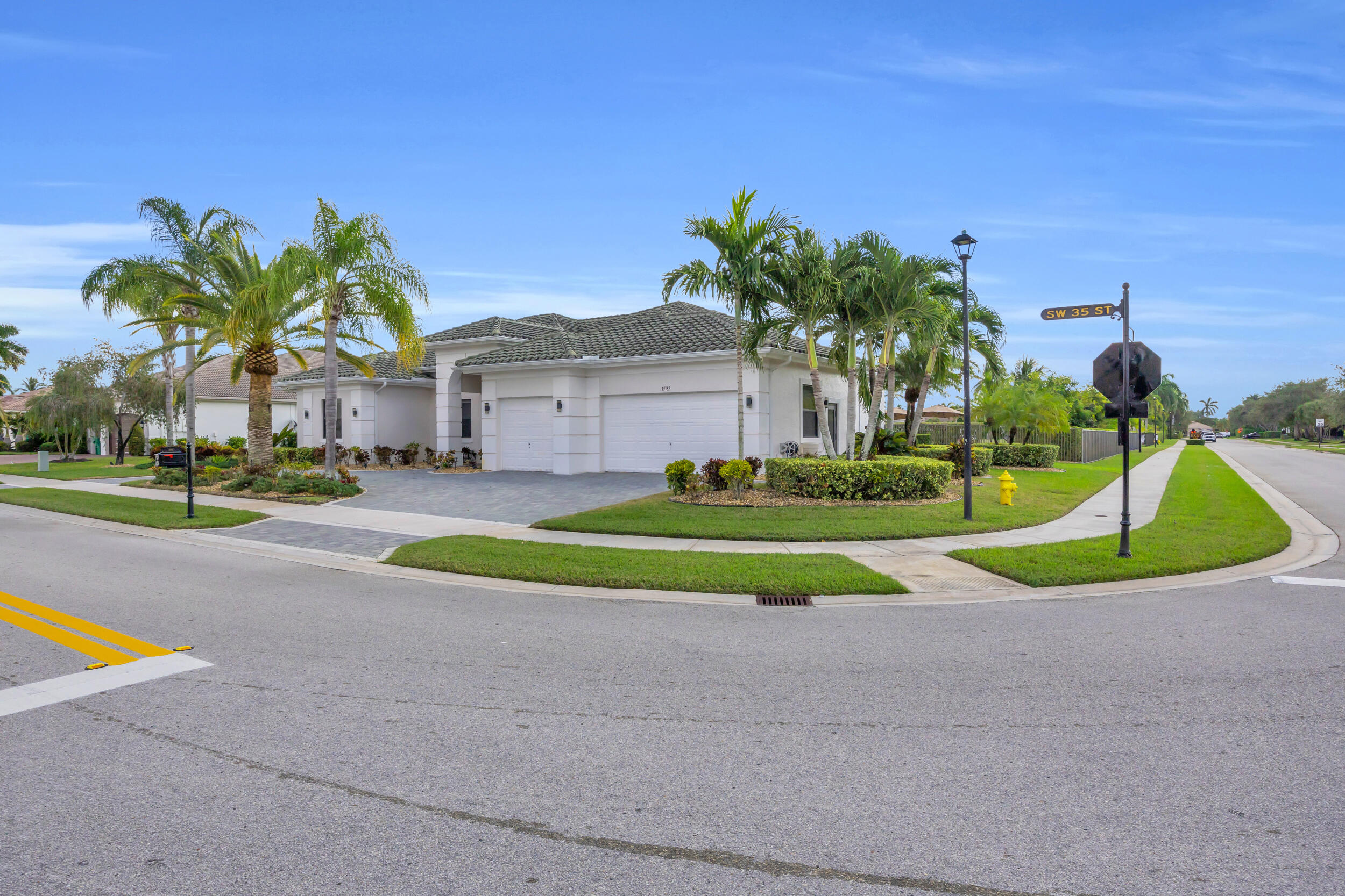 Welcome to this beautifully designed 4 bedroom, 3 Bathroom 3-car garage home set on an expansive corner lot just shy of an acre in the highly desired Riverstone community. A fully paved circular driveway, lush landscaping, and a classic barrel-tile concrete roof (2017) create an unforgettable first impression. Step through the oversized steel-and-glass French doors into a bright, elegant foyer leading to a formal sitting room with picture-perfect views of the pool and lake. This home has natural light from its tall windows and clerestory accent windows throughout, giving every room a warm, feel. The main living areas feature tile flooring, while the bedrooms offer rich wood floors. The spacious living room flows into a welcoming kitchen with granite countertops, tall vaulted ceilings, and controlled blinds for effortless comfort. The extra-large primary suite is a private retreat, offering serene views of the backyard and pool, tray and vaulted ceilings with can lighting, and an impeccable California-style custom closet a dream for anyone who loves organization and style. The primary bath includes a Roman tub and dual sinks, and the convenient cabana bath provides easy access to the patio. Outdoors, entertain in style with a sparkling pool, wide open green spaces, and beautifully placed **fruit trees mango, guava, avocado, and cherry **while still leaving plenty of yard to enjoy. The home also features indoor and outdoor Bluetooth speakers for effortless entertaining, along with custom security cameras for added peace of mind. Riverstone offers a low HOA while still providing a clubhouse, tennis court, and playground. You're also moments from Vista Park's trails and recreation, as well as top shopping, dining, and medical facilities. This home blends elegance, functionality, and Florida living at its finest and with a lot size like this, it will not last long.