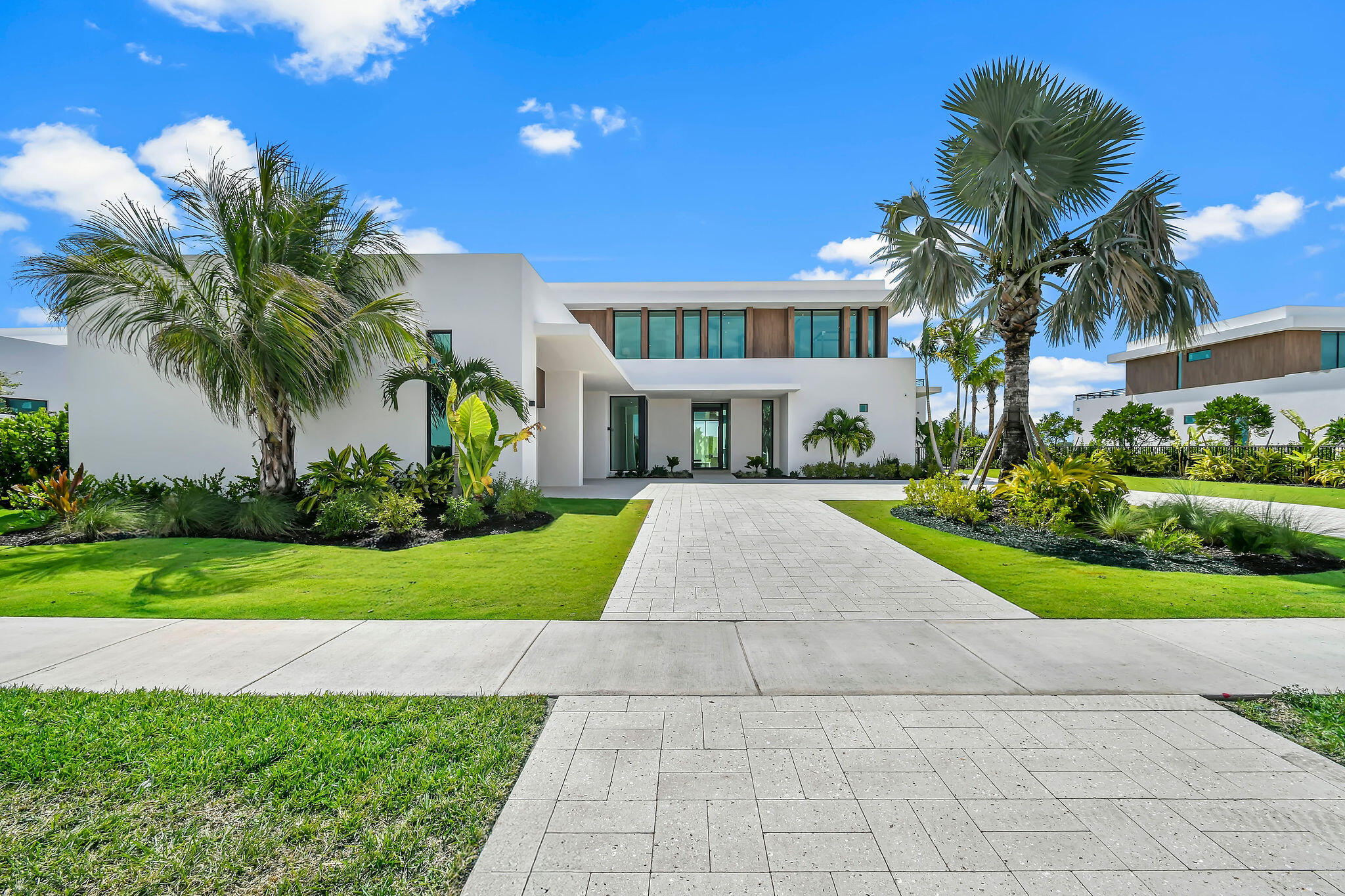 Ultra-Modern Masterpiece in Panther National - Designed by Max Strang Experience architectural brilliance in this striking ultra-modern estate, designed by renowned architect Max Strang, located in the prestigious new golf community of Panther National in Palm Beach Gardens. Seamlessly blending sophistication with cutting-edge design, this residence sets a new standard in luxury living. With 5 spacious bedrooms and 8 luxurious bathrooms, every detail has been curated to perfection, offering comfort, privacy, and functionality for both family and guests. The open-concept floorplan showcases soaring ceilings, walls of glass, and sleek finishes that capture natural light while framing the breathtaking golf course and lake views. The gourmet chef's kitchen is a work of art, featuring custom cabinetry, top-of-the-line appliances, spacious walk-in pantry, catering scullery; and a seamless flow into the expansive living and dining spaces which are showcased by a stunning glass wine cellar. Perfect for entertaining, the indoor-outdoor integration opens to multiple terraces, a resort-style pool, and private lounge areas that embrace Florida's lifestyle year-round. The owner's suite is a private sanctuary, complete with private sitting areas, expansive terrace, 2 spa-like bathrooms, dual designer closets, and sweeping panoramic views. Additional guest suites are designed with luxury and privacy in mind, while flexible spaces allow for a home office, fitness studio, or media room. A 4-car garage offers ample space for the automobile enthusiast, complemented by clean architectural lines and a modern façade that make a powerful statement from the moment you arrive. Aa members of Panther National, residents enjoy access to exclusive amenities, including a world-class Jack Nicklaus Signature golf course in collaboration with Justin Thomas, wellness and lifestyle facilities, fine dining, and a community designed for the most discerning buyers. This property is not just a home, it is an architectural landmark, a statement of modern elegance, and a rare opportunity to own a Max Strang original in one of Palm Beach Gardens' most coveted new golf communities. Welcome to paradise- 10955 Monte Rosa Dr.!  Features of Interest: Smart Home technology throughout Lutron Lighting throughout Automated shades Motorized screens Water detection system Elevator Solar panels EV charging in the garage