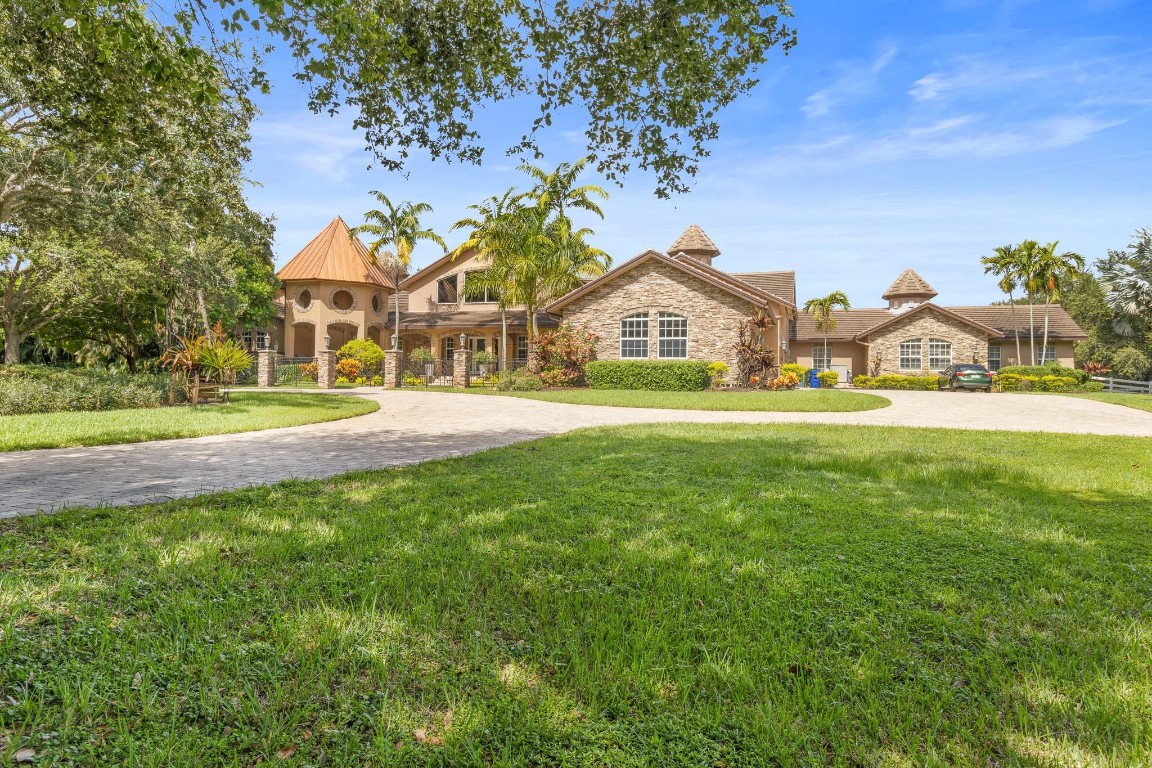 Welcome to one of Sunshine Ranches' most premiere rare 10-acre +/- luxury estate, where sophistication gracefully intertwines with nature's beauty. This immaculate 5-bedroom residence boasts en-suite baths, a home theatre, and a private office for seamless living. Entertain in style with a delightful patio, summer kitchen, and an inviting outdoor fireplace that set the scene for unforgettable gatherings around your resort style pool. Equestrian enthusiasts will relish the blissful paradise, featuring 2 stables with 6 & 8 stalls, riding rings, and ample turnouts. Embrace the tranquility of 115+/- majestic oak trees that adorn the landscape, creating an idyllic ambiance. Experience the perfect balance of exclusivity and convenience in the highly sought-after Southwest Ranches community.