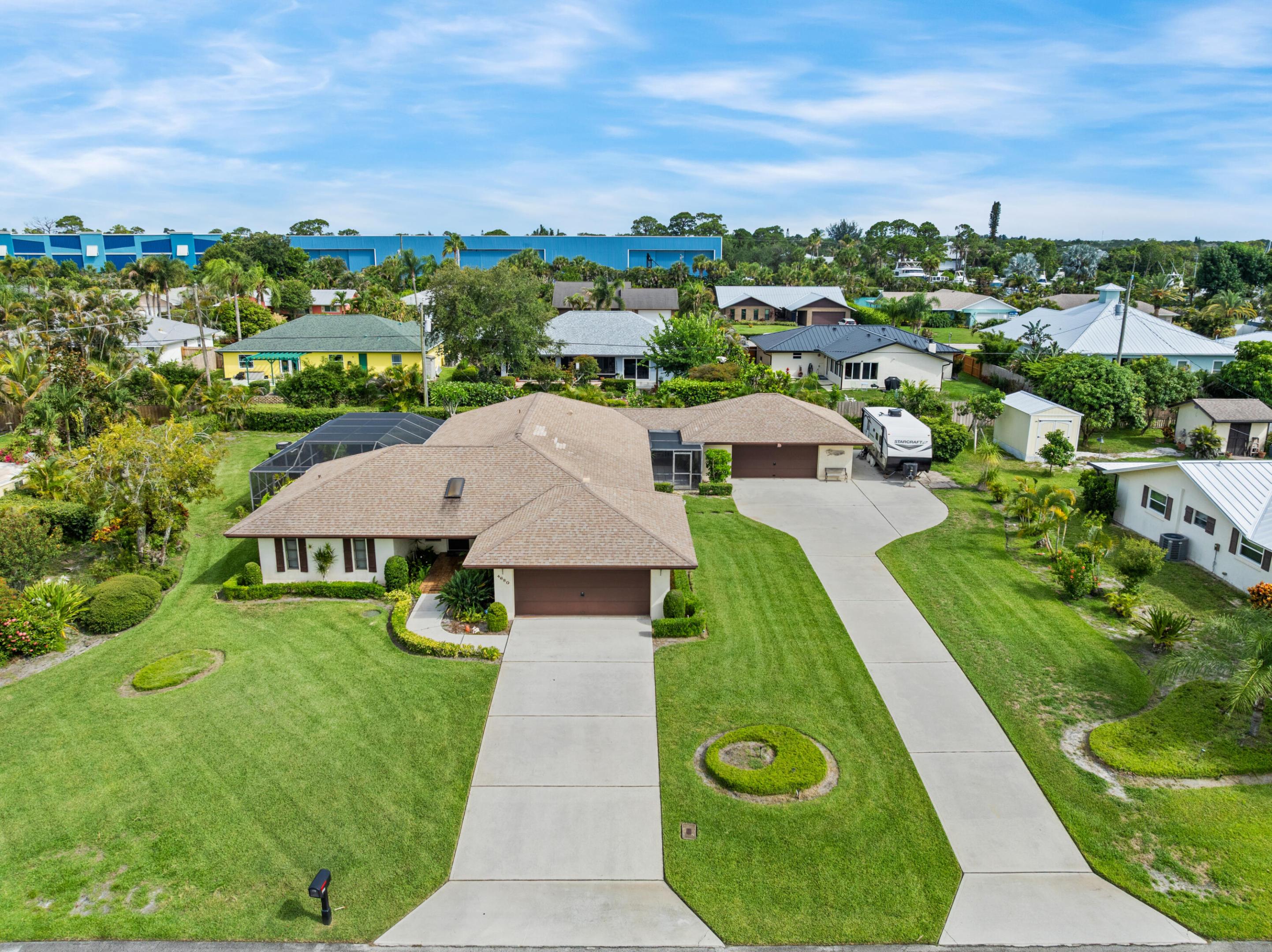 This is a unique opportunity to acquire a home on half an acre in Rocky Point. The property features CBS construction, a pool, and an attached two-car garage, along with a detached two-car garage that has a separate driveway. Properties like this are rarely available in Rocky Point, and the possibilities are limitless, including the potential for a guest house, garage conversion, or additional structure on the property. The main house has under roof area that can enlarge the footprint of the home under air, and the detached garage is just under 700 square feet with front and rear entrance. This home has never been on the market before and is being shown for the first time.  Enjoy Magie's Hammock and Twin Rivers Park within the take advantage of being close to the Manatee Pocket for waterfront entertainment and dining. Known as the Sailfish Capital of the World, this is a perfect location for fishermen, with easy access to the inlet and Stuart sandbar.