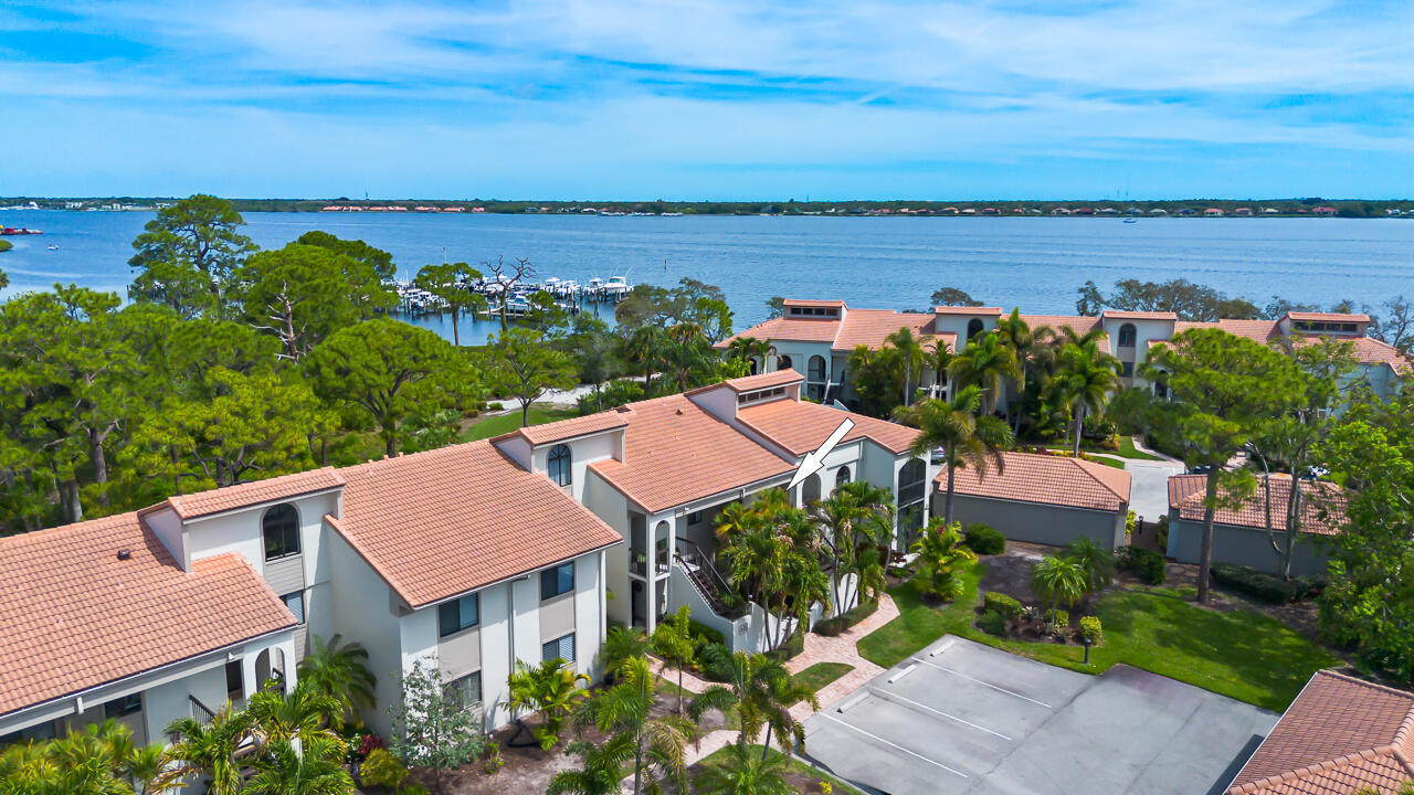 Discover elevated waterfront living in Bayhead Village at Harbour Ridge, one of Palm City's premier private golf and yacht club communities. This beautifully maintained 2nd-floor end-unit condo offers panoramic St. Lucie River, and marina views with exceptional privacy and abundant natural light. Featuring vaulted ceilings, walls of glass, a spacious open-concept floor plan, stylish updated kitchen, enclosed lanais for expanded living space, newer washer/dryer, plus a versatile 3rd bedroom ideal for a home office or den. Carport, community pool and walking trails just steps away. Perfect for luxury buyers seeking a Florida waterfront lifestyle, private club amenities, boating, golf, pickleball, fitness, and resort-style living. Harbour Ridge offers 2 championship golf courses, marinas with slips available and boat shuttle to award winning Downtown Stuart for shopping and dining.  Gorgeous waterfront clubhouse, dining, spa, salon, tennis, dog park, , and 24-hour guard-gated security. Mandatory $125,000 equity membership required.