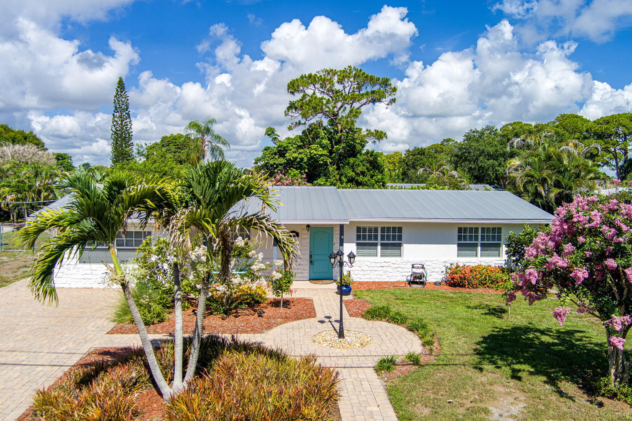 If you are looking for the perfect three bedroom home with a screened POOL, close to downtown Stuart and the beaches, this could be the home for you! From the moment you arrive, this move-in ready pool home offers the Florida lifestyle buyers are looking for, complete with a heated in-ground screened pool, impact windows, and a durable metal roof.  Inside, the home features easy-maintenance laminate and tile flooring throughout, creating a clean and comfortable flow from room to room. The kitchen offers granite countertops and generous workspace, making it easy to prepare meals, entertain guests, or enjoy everyday living. An additional den or entertainment room provides flexible space that can be used as a media room, home office, hobby area, or guest retreat. Step outside to the screened pool area and enjoy your own private outdoor escape, perfect for relaxing, swimming, or entertaining year-round. This is the PERFECT home for a first time buyer or great investment property! Can be rented seasonally or as an AIRBB. Conveniently located near shopping, dining, parks, boating, downtown Stuart, and the beautiful beaches of the Treasure Coast, this home delivers comfort, location, and value all in one. Competitively priced and ready for its next owner, this is Florida living at its best.