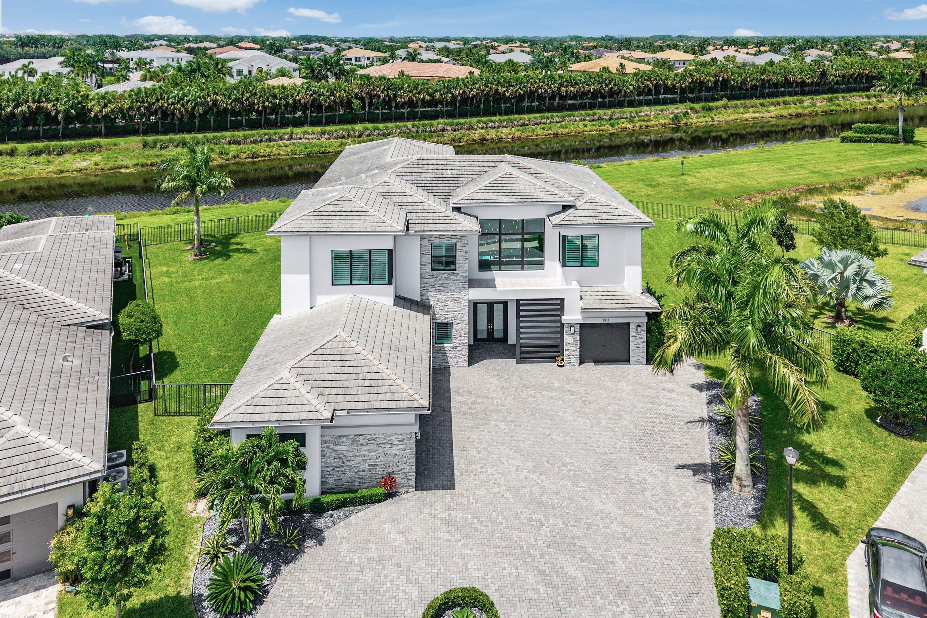 Nestled behind the prestigious gates of Boca Bridges, this contemporary Palermo is ideally situated on a sprawling 1/2 acre property in a cul-de-sac with extensive customization throughout. This stunning estate spans over 6,000 sf of exquisitely decorated living space and features a custom kitchen with Wolf/Sub-Zero appliances, living room with custom bar and fireplace, custom tile and engineered wood flooring, a full house generator and water filtration system. The vast backyard oasis has serene water views and hosts a 40x22 heated saltwater pool with waterfall bowls and linear fireplace. Luxury living is redefined at Boca Bridges where residents have access to resort amenities inclusive of a restaurant, beach entry pool, kids splash park, fitness center, tennis and pickleball courts.