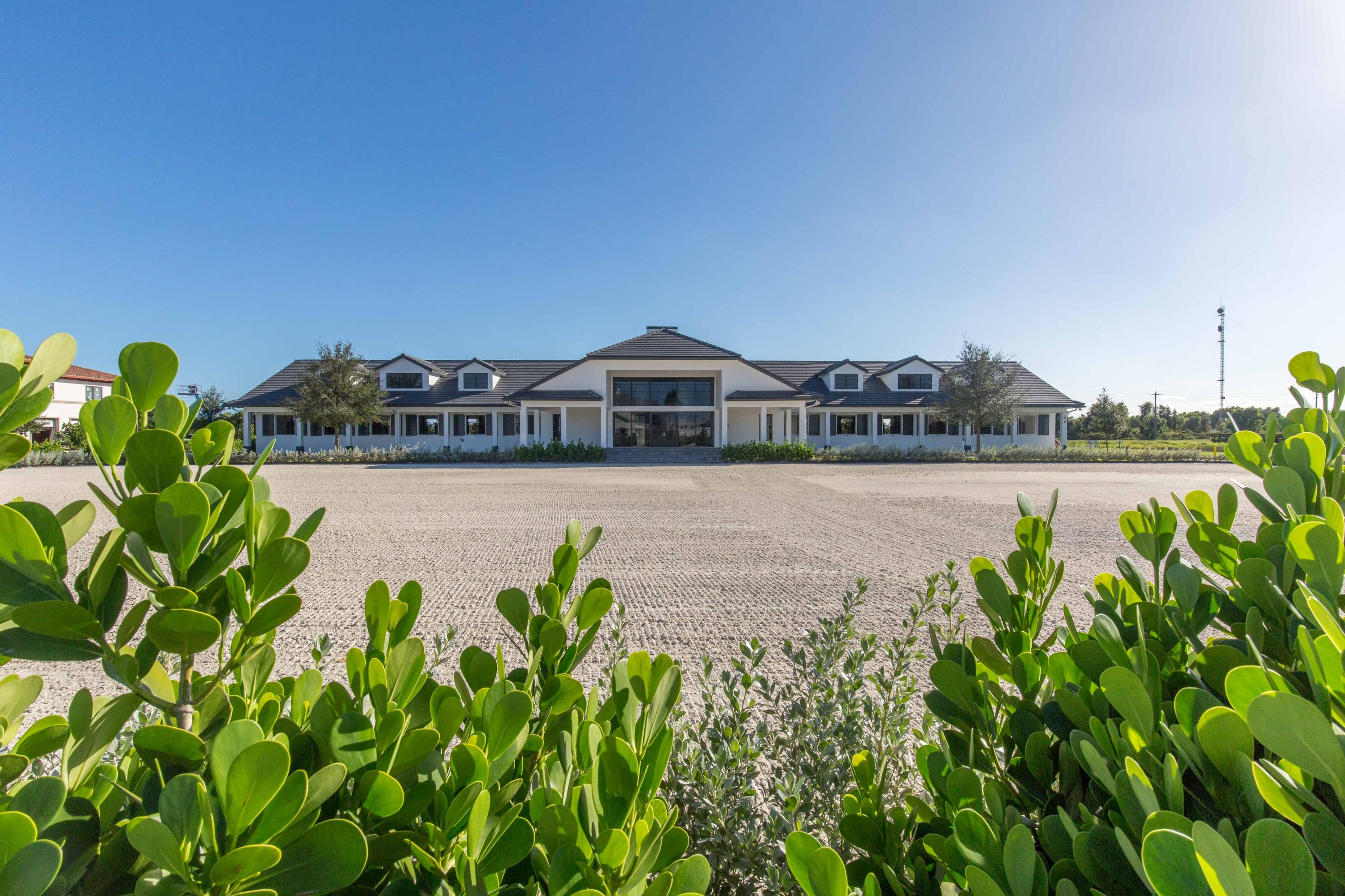 This brilliantly appointed Grand Prix Village South property is an absolute must-have. Situated on 4-acres of lush land, is an amazing 20-stall barn with 4 wash stalls, 2 tack rooms, a laundry room, and a feed room. Absolutely no expense was spared in the creation of this masterpiece. The owners' lounge has a beautiful fireplace as the focal point, as well as a kitchen with great room for entertaining and a wonderful view of the 220' x 120' all-weather ring with superior custom footing. Property also includes six paddocks and a separate grooms' apartment with 4 bedrooms and a large kitchen.