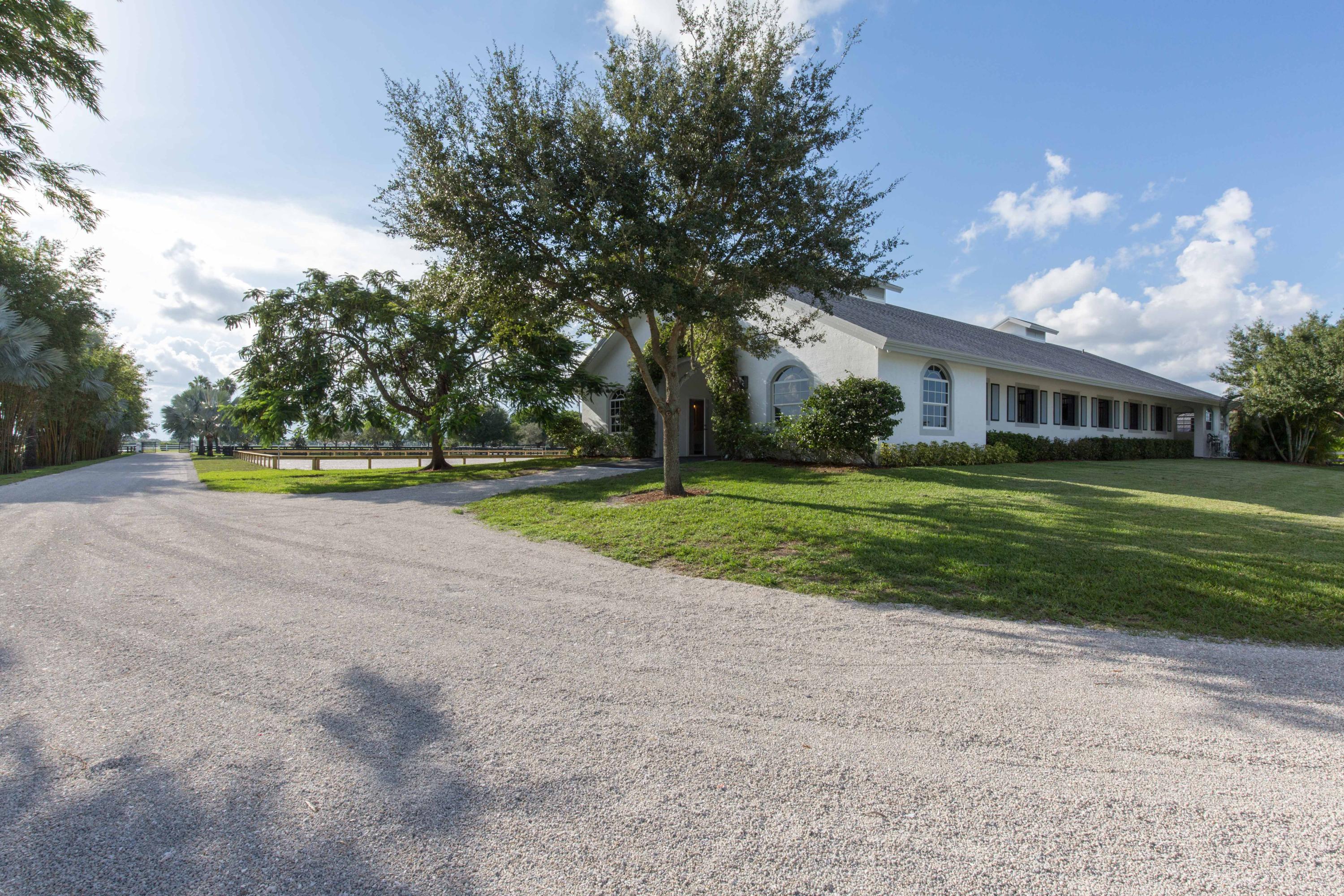 Over five well-maintained acres hosts a beautifully renovated barn in Palm Beach Point East that is well equipped for jumpers wanting to enjoy sunny South Florida and is located within hacking distance to WEF showgrounds.  A bougainvillea arch leads into the 12-stall center aisle barn which hosts a one-bedroom, one-bathroom groom’s apartment, sizeable wash racks and a comfortable tack room with ample storage and laundry.  Four manicured paddocks offer a generous amount of space, optimal grass and shade from the sun.  Just steps outside of the barn, a gazebo is ideally situated overlooking the ring, making it a perfect spot to hang out and watch the action.