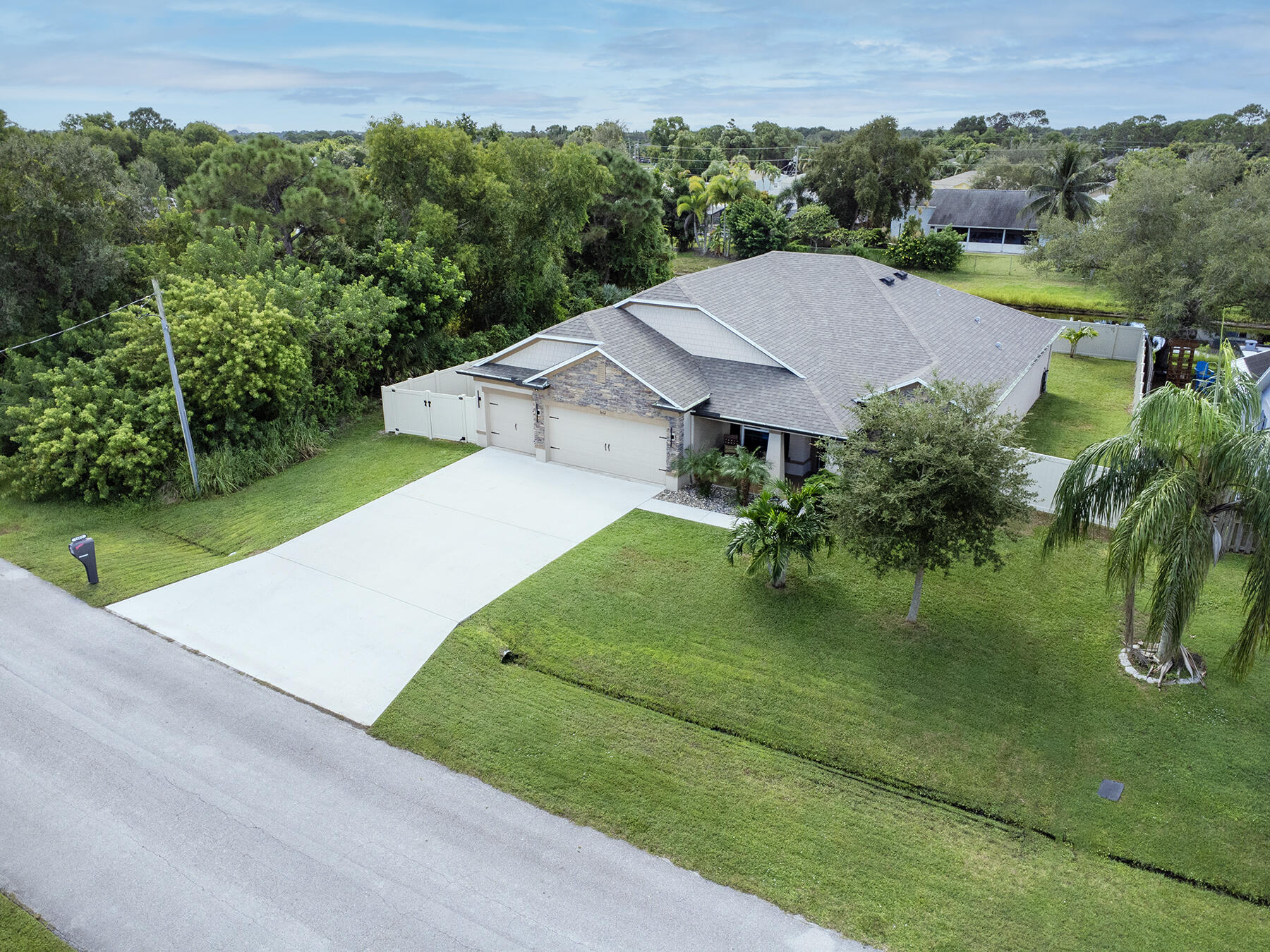 APPRAISED AT $575,000 | INSTANT 10k EQUITY OPPORTUNITY | COASTAL LOCATION | AFFORDABLE FLORIDA LIFESTYLE | THE SELLER IS OFFERING A $2,500 BUYER CONCESSION AT CLOSE | Live the coastal lifestyle in this beautifully upgraded 2019 CBS home on a canal lot East of US-1 just minutes from beaches and boating. No HOA—park all your toys in the 3-car garage, 6+ car drive, or dedicated boat/RV space in the separate fenced side yard. Enjoy an open layout featuring ceramic tiles throughout (NO CARPET) and a chef's kitchen with double oven, granite counters, and stainless appliances. Upgrades include a real stone front, the hot tub spa, and privacy fenced yard. This home combines modern construction, coastal convenience, and immediate equity. REACH OUT AND SCHEDULE YOUR PRIVATE TOUR TODAY. Welcome to this clean, pristine, beautifully upgraded 2019 Maronda Sierra Plan offering 4 bedrooms, 3 bathrooms, and a versatile flex space front room. | Built with SOLID CBS CONSTRUCTION, this modern traditional home showcases an UPGRADED REAL STONE FACADE, wrap-around gutters, and an EXTENSIVE  6+ CAR DRIVEWAY. The interior is thoughtfully finished with UPGRADED durable ceramic tile flooring throughout, ABSOLUTELY ZERO CARPET! The UPGRADED CHEF'S KITCHEN features premium granite countertops, a double oven, a sleek glass cooktop, and generous workspace workspace for all your fantastic cooking! The spacious primary suite includes an UPGRADED OVERSIZED WALK IN SHOWER with a rain showerhead, while the ENSUITE GUEST BEDROOM offers an UPGRADED  walk-in shower for added comfort and guest or your Teens privacy. Additional interior highlights include white wood-look blinds, DOUBLE-PANE ENERGY-EFFICIENT WINDOWS, full HURRICANE SHUTTERS a smart home security system, and a large laundry room with custom cabinetry and a folding counter. | Enjoy exceptional outdoor living on the covered back patio equipped with COLOR-MATCHED ELECTRIC PRIVACY SCREENS and a relaxing HOT-TUB SPA. Set on a peaceful canal lot, the fully fenced backyard offers maximum privacy and functionality, including a DOUBLE GATE and a separate fenced side yard IDEAL FOR BOAT OR RV PARKING. The attached 3-CAR GARAGE includes a practical utility sink and enough space for storage and hobbies. |  Situated in a highly desirable EAST-OF-US-1 location near the Green River Parkway Trail and Savannahs Preserve and State Park, this property sits just minutes from the Martin County line. It offers quick access to the INTRACOASTAL and local beaches without the higher county price tag. With easy connectivity via US-1 or scenic back roadways, you are just minutes away from the Treasure Coast Mall, everyday shopping, and the vibrant dining and entertainment districts of downtown Jensen Beach and downtown Stuart. This home perfectly delivers space, premium upgrades, and total FLORIDA LIFESTYLE appeal!