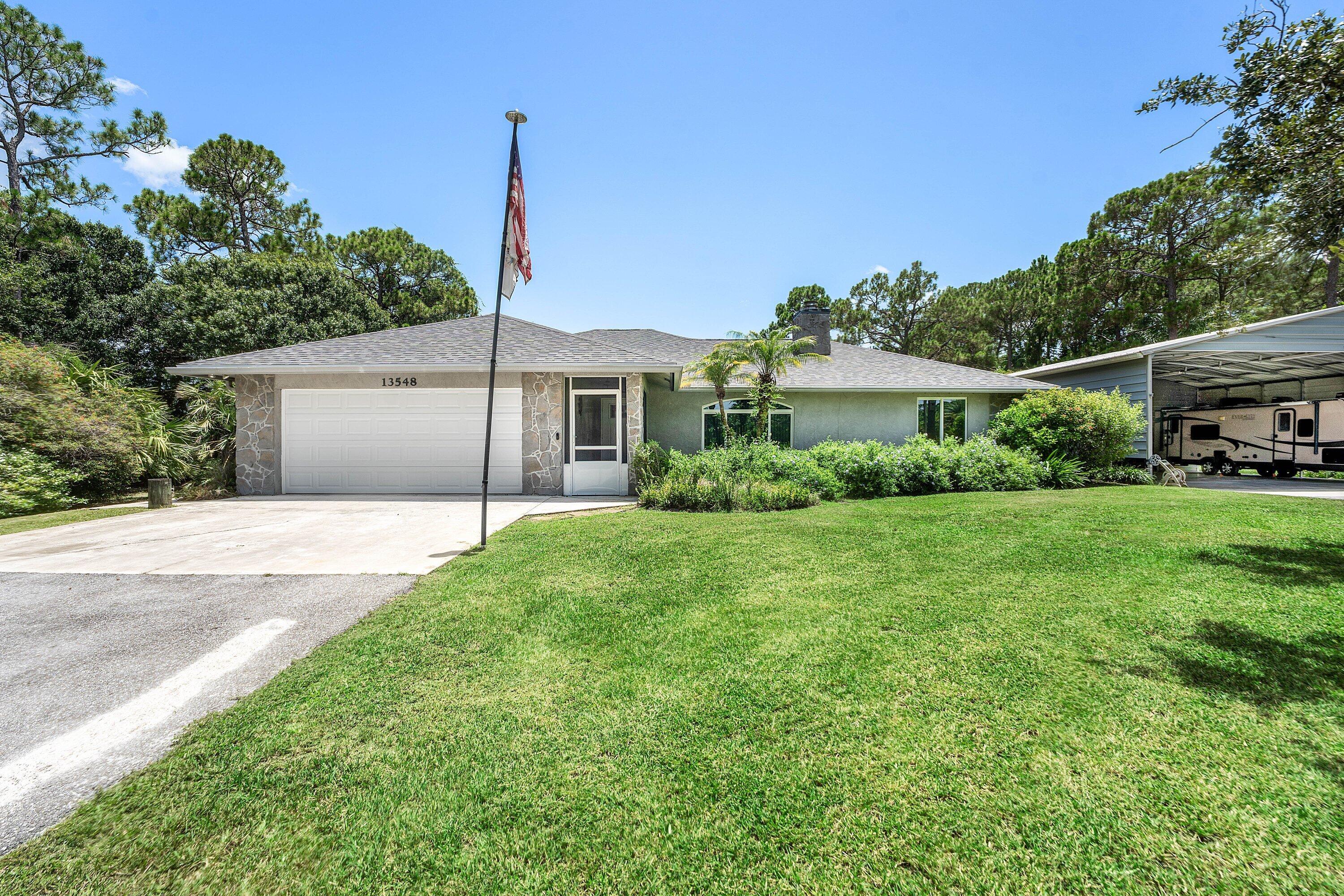 Welcome to this charming 3-bedroom, 2-bathroom single-story residence in The Acreage, West Palm Beach. Offering 1,498 square feet of finished living space, an attached 2-car garage, front and rear screened porches, and a detached 35 x 45 carport with enough space for boats, RV's and all the toys. Kitchen and bathrooms have been updated. Impact glass windows and exterior doors for hurricane protection. New roof is less than one month old. This single-family residence delivers  straightforward, country living in an established community setting. Vacant and easy to show.
