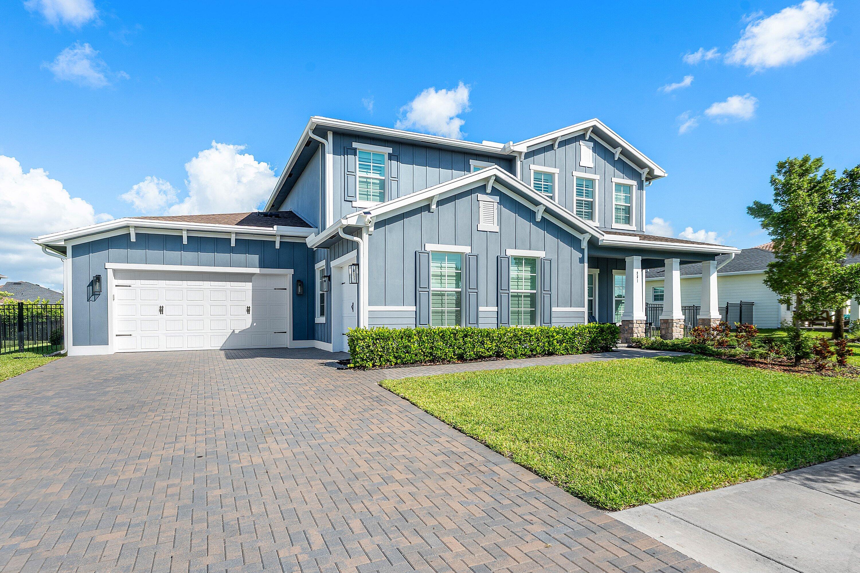 Beautifully positioned on a premium homesite with tranquil green space views and room for a custom pool and spa, this extensively upgraded two story residence offers over 3,700 square feet of refined living in the award winning Arden community. Featuring 5 bedrooms, 4.5 baths, and an impressive collection of designer enhancements, this home seamlessly blends luxury, comfort, and modern functionality. A widened driveway and inviting curb appeal welcome you into soaring interiors filled with natural light, high ceilings, and an exceptional sense of openness throughout. Elegant plantation shutters span the entire home including the garages, complemented by upgraded hardware, designer cabinet pulls, custom millwork, and elevated finishes that create a polished and cohesive aesthetic. Thoughtfully designed for both entertaining and everyday living, the spacious floor plan features a private study, formal dining room, expansive loft, and open concept living spaces that flow effortlessly together. The Great Room is anchored by custom built ins with two tone lighting and a sleek electric fireplace, creating a warm yet sophisticated focal point. At the heart of the home, the gourmet kitchen showcases quartz countertops, upgraded backsplash details, premium Arhaus lighting, under cabinet lighting, and an upgraded Bosch dishwasher, all seamlessly connecting to the breakfast nook, Great Room, and covered lanai for effortless indoor outdoor living. The first floor owner's suite offers a luxurious private retreat complete with custom closets, illuminated and heated mirrors, convenience outlets, premium finishes, and a spa inspired atmosphere designed for both beauty and comfort. Upstairs, four generously sized en suite bedrooms surround a spacious loft featuring custom built ins with designer lighting, providing ideal flexibility for guests. Additional upgrades include premium ceiling fans, upgraded washer and dryer, UV lighting in the AC systems, a custom mudroom with built in storage benches and shiplap detailing, a charming doghouse nook beneath the stairs, epoxy coated garage floors, overhead storage racking, and custom slat wall organization systems in both garages. Located within one of Palm Beach County's premier master planned communities, Arden is celebrated for its award winning Farm to Table lifestyle centered around a 5 acre working farm and event barn. Residents enjoy resort style amenities including a clubhouse, pool, state of the art fitness center, 20 miles of scenic walking and biking trails, lush green spaces, lakes, seasonal community events, and access to top rated schools, all while being conveniently close to shopping, dining, equestrian venues, golf resorts, and Palm Beach County's beautiful beaches.