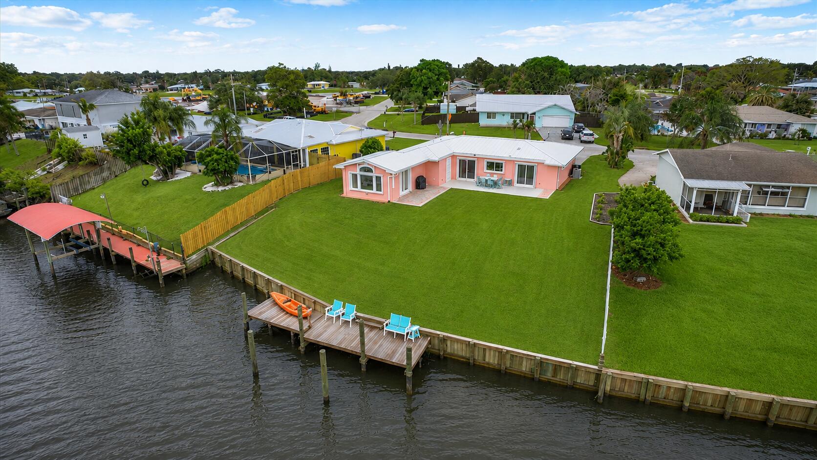 Beautifully maintained 3 BR, 2.5 BA waterfront home with 94' of frontage on a wide canal and ocean access! This move-in-ready gem features a new metal roof, new dock & seawall, newer A/C, appliances, solid-core doors, accordion shutters throughout w/tile & vinyl flooring. The spacious floor plan is perfect for relaxing or entertaining & the cabana bath perfect for entertaining outside. Enjoy these stunning water views from the expansive backyard & open patio. Additional features include a gravel-packed well for irrigation and a converted garage. Furniture, kayak, and 2019 jet ski included with accepted offer. Ideal as a primary residence, vacation retreat, long-term rental, or Airbnb investment. MOVE IN CONDITION & MUST SEE! Garage has been converted to include a laundry room, storage area and for all your other toys. Home is wired for a generator and features a concrete pad with water and electric already in place for a future pool and/or spa installation. 35-45 minute boat ride to the intercoastal. Room for a pool if you desire. Close to shopping, restaurants, schools, hospital & beaches.