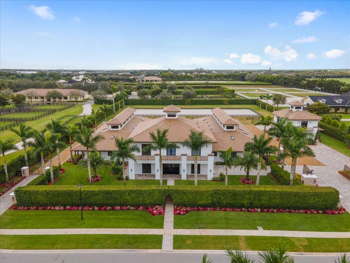 This custom built private farm spared no expense with it's thoughtful design and construction. Situated on 2.5 acres, this property offers 18 stables that are equally divided to reflect one another. Each side equipt with 2 grooming stalls, 2 wash stalls, 2 feed rooms with washer/dryer and 2 lounges with half baths. The outdoor arena is 200x70 with room to expand if needed and surrounding paddocks. The owners quarters feature 3 bedrooms and 3 baths, all en-suite with walk-in closets. There is a state-of-the art kitchen dressed with Thermador Pro collection appliances and parallel to the expansive covered patio. Enjoy outdoor living with a beautiful summer kitchen to include Alfresco BBQ all while overlooking the arena and paddocks. There is a 2 bedroom, 2 bath guest house that rests above a spacious 3 car garage/storage area. Fully independent with kitchen, living, laundry facility and balcony! With numerous upgrades to include extensive security system, interior/exterior pavers, handmade cabinetry throughout the entire property, Cypress ceilings with cupulas and city utilities including water, electricity, sewer and Fibre. Enter this fabulous property through a private Grand Prix Farms owners gate while enjoying all of the amentities the Equestrian Club has to offer.