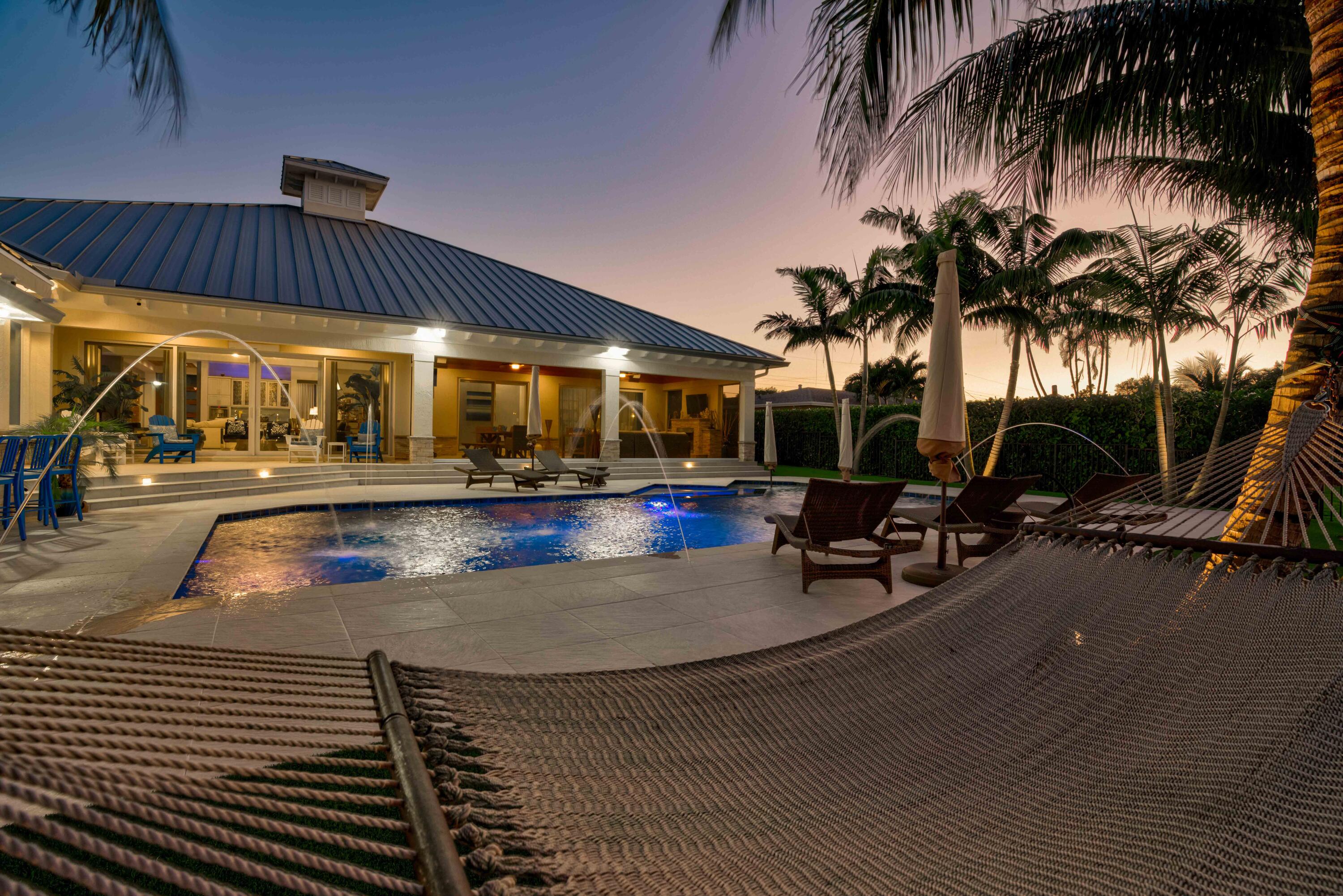 Incredible value at this stunning, modern estate home on 100' of waterfront has it all! Designer finishes and fully furnished. Salt water pool with spa and jets.  One of the best ''NO HOA'' streets in PBG, wide/deep salt water canal. No fixed bridges & easy ocean access. This newer premier estate home has 5 bedroom, 5.1 bath plus office, 3 car garage, impact glass 24KW generator, 24K boat lift. Tiki bar, outdoor kitchen, oversized covered living/dining with motorized screens.  Gourmet gas appliances. Open concept with no detail left undone.  Walk through this Mahogany door into a spectacular foyer with wood tray ceiling and salt water fish tank.  Master bedroom plus 3 additional en suite bedrooms plus office in the main house and separate 1/1 guest house/casita.