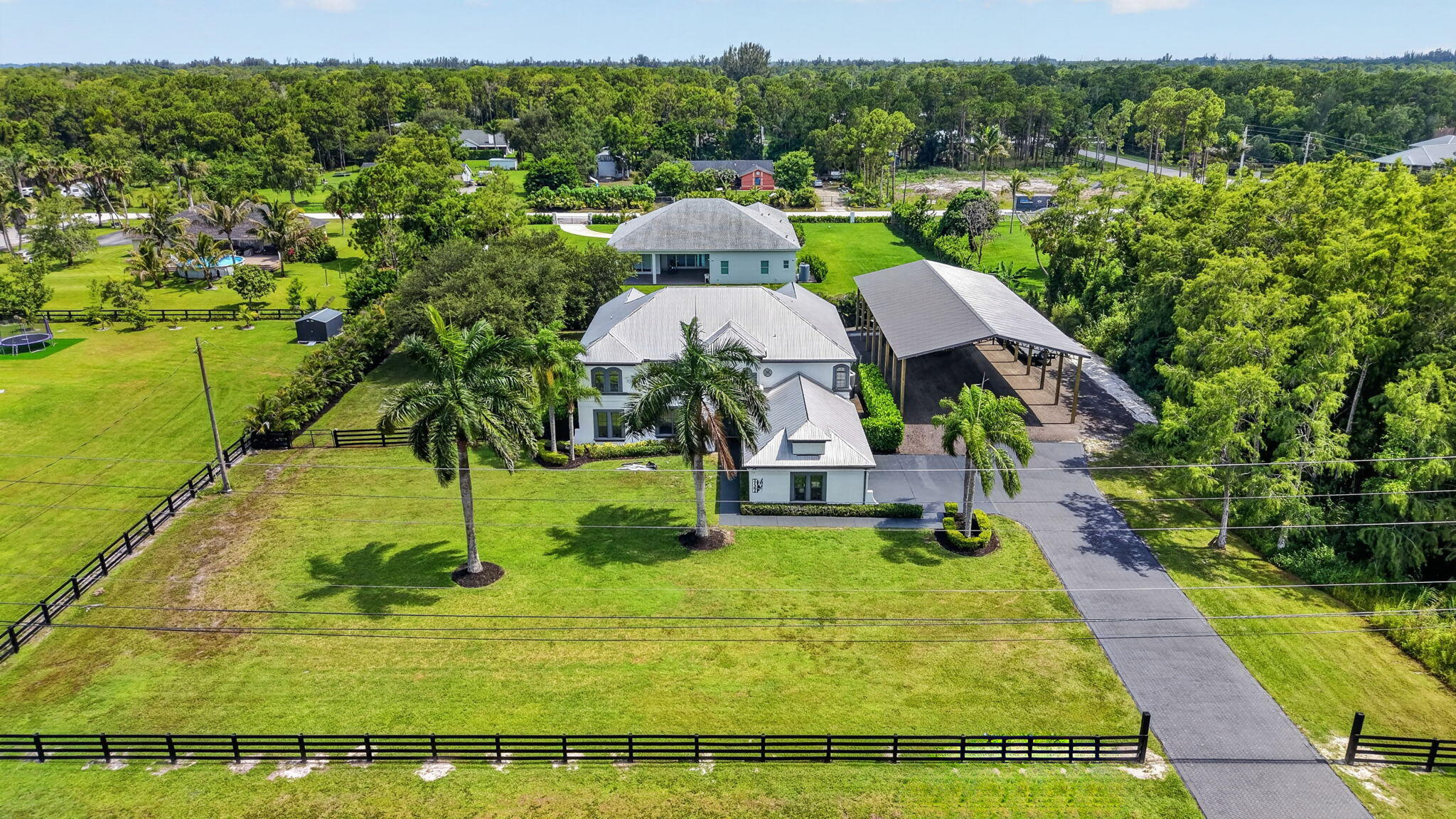 Experience luxury country living with every modern convenience in this fully renovated smart home situated on 1.2 private acres. Designed for both everyday comfort and exceptional entertaining, this one-of-a-kind home features a new metal roof (being installed), an impressive 84' x 40' pole barn with endless possibilities & no expense spared for the Summer Kitchen. Inside, you'll find a spacious & versatile floor plan featuring 4 true bedrooms, a dedicated office, game room & movie theater with real movie theatre carpet. Built with technology in mind, this true smart home includes 22 miles of CAT6 wiring, a comprehensive security system with 13 Ring cameras and ceiling speakers throughout the home and outside under covered areas. All concrete work at home was done by Thiel Studio Designs. The chef's kitchen showcases custom concrete countertops by Thiel Studios, premium Energy Star appliances and a Thor gas range. The luxurious primary suite offers a spa-like retreat featuring a steam shower, separate steam room, and high end designer fixtures. Step outside to your private backyard oasis featuring a fully remodeled Cabana bath as of last year, a gorgeous built-in summer kitchen complete with a propane grill, propane hibachi grill, built-in XL Big Green Egg, 2 refrigerators, cold drawer, ice maker, sink, abundant storage, and custom concrete countertops handcrafted by Thiel Studios, known for their work on The Vanilla Ice Project. Recessed lighting throughout the covered patio creates the perfect setting for entertaining day or night. Additional upgrades include a whole-house propane tankless water heater, full-house Reverse Osmosis water filtration system with an 800-gallon storage tank, ceramic window film that blocks UV rays and heat while improving energy efficiency, impact-rated French doors in the kitchen and a new impact-rated upstairs picture window, and 3 A/C systems. Quartz countertops in cabana bath and upstairs bathrooms. There are 2 dedicated 20 amp lines in attic if the buyer would like to hook them up for the movie theater. Please see additional info sheet attached in the documents section of the listing for extra details on home.