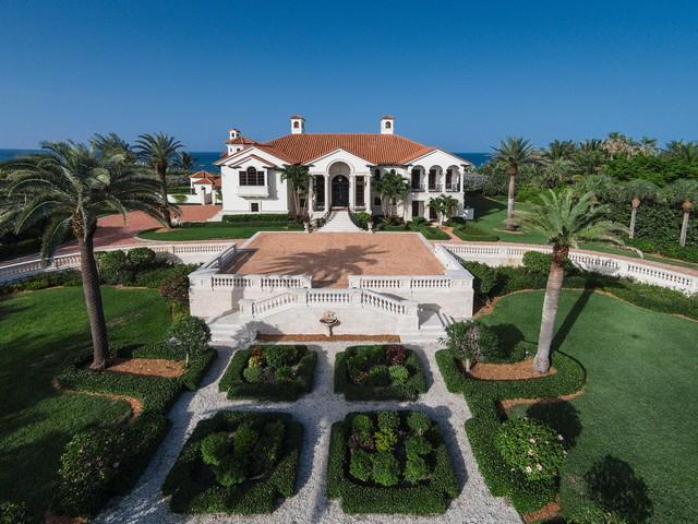 Inspired by the Palladian Villas of Italy, this Oceanfront estate situated on a 2-acre site with 300’ of Atlantic shoreline, complete with an array of exotic materials, offers a feel of effortless luxury and comfort.  Some features include groin vaulted ceilings of reclaimed chestnut, 2 professional grade kitchens, 3 gas fireplaces, cloistered ceilings, hand carved limestone columns, iron and brass railings, hand rubbed walls, marble, limestone, lapis lazuli, onyx, cypress and mahogany wood and hand-made barrel tile roof. Outdoors, the villa makes its entrance with an expansive balustrade motor court surrounding exquisite European style gardens with fountains, Oceanside pool and elevated dune walkway for private beach access. This is a must-see Sailfish Point residence!