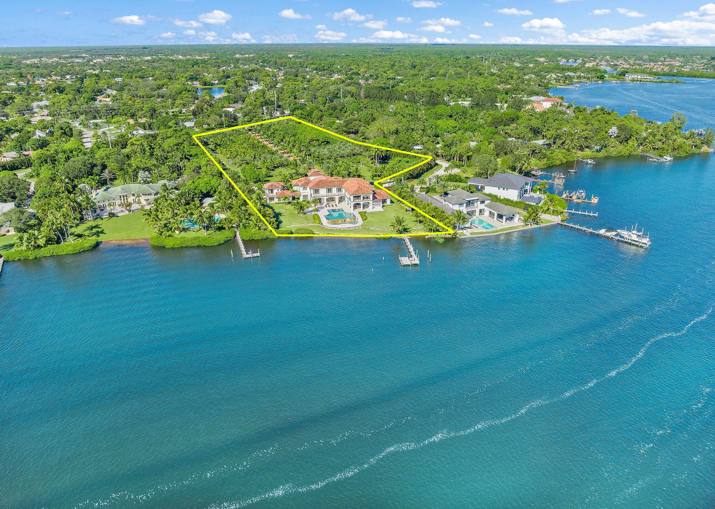 EXQUISITE OPPORTUNITY to Own the Largest Assemblage of Waterfront Land available in JUPITER!  This legacy property boasts a majestic 6.25 Acres with 254' of wide water frontage.  Offering the Ultimate in Privacy + Security, this modern palazzo boasts an imposing 18,302 sq. ft.  A gated 640' palm treed drive leads to this stunning abode. Masterfully built in 2016 by award winning Anderson Moore using only the finest materials, this home features full Control 4 automation. Interiors include a soaring 2 story entry, stunning wood + marble floors + mouldings, creating a magical ambiance. Finely curated furnishings provide an exquisite move in ready haven. The hub of the home is the grand kitchen and family room, an elegant oasis of luxury + comfort.  The professional ASID award winning kitchen is designed to stylish perfection while offering the finest in functionality. Adjoining massive family room is outfitted with Automated sliding doors opening to the grand loggia, blending indoors + out. Inside, a private elevator + grand staircase leads to the second level and upper gallery. The Owner's suite delivers unparalleled luxury, from the grand hall entry with morning bar to the opulent marble bath and dual wardrobe rooms. A private loggia offers exquisite serenity. An additional 5 spacious bedrooms with ensuite baths + large closets are in the main house. A separate 1,800 SF guest house has 2 additional ensuite bedrooms. Villa Real offers every amenity of comfort + style, from the dramatic double level pool to huge waterfront loggias w/ fireplace and summer kitchen as well as a home theatre. Enchanting grounds with endless water views + Ocean breezes and a 107' dock along the Loxahatchee River provides a protected and easy path to the Jupiter Ocean Inlet. See Documents for Property Info + Surveys.  A beautiful life awaits you...