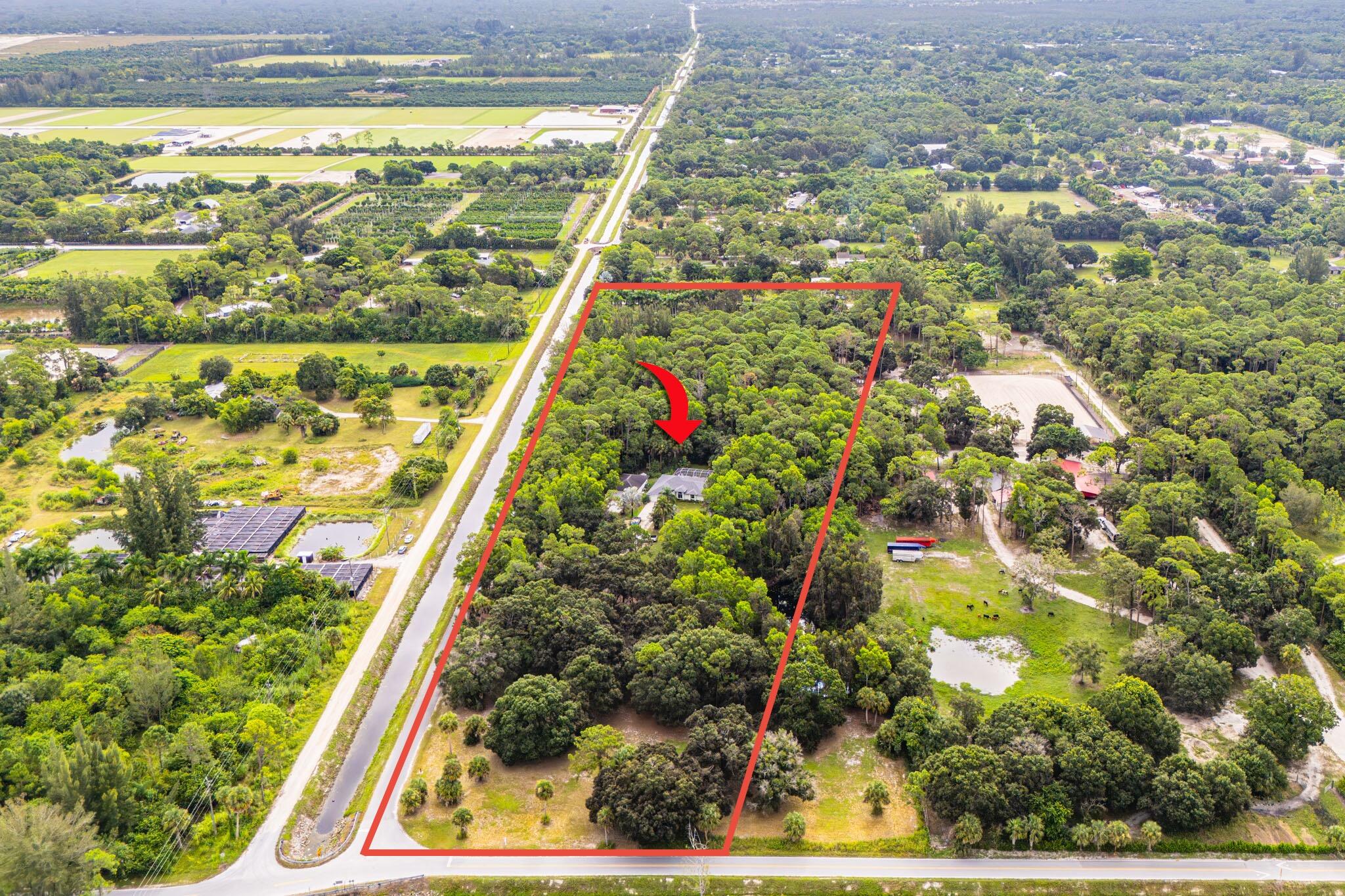 RARE 10-ACRE PRIVATE ESTATE MINUTES FROM WELLINGTON! Discover an exceptional opportunity to own 10 acres of privacy, space and versatility in Loxahatchee Groves. This unique property combines a private residence, pool, pond and an impressive 1,040-square-foot detached CBS garage/workshop, creating endless possibilities for the buyer seeking acreage without sacrificing proximity to Wellington, equestrian venues, shopping, dining and everyday conveniences. A long private drive leads you into the property, where mature landscaping and expansive grounds create a peaceful setting with room to enjoy, expand and make the property your own.  The residence features 3 bedrooms, 2 bathrooms and approximately 1,600 square feet of living space, complemented by a private salt water pool for enjoying the South Florida lifestyle. One of the property's standout features is the substantial detached CBS garage/workshop, offering exceptional space for a car collection, equipment, storage, and/or hobbies. Whether you're searching for a private acreage retreat, space for your vehicles and equipment, a property with room to create your future vision, or a rare opportunity to own 10 acres near Wellington, this property offers a combination that is increasingly difficult to find. Experience the privacy, possibilities and lifestyle of 10 acres in one of western Palm Beach County's most desirable acreage communities. Schedule your private showing and discover everything this unique property has to offer.