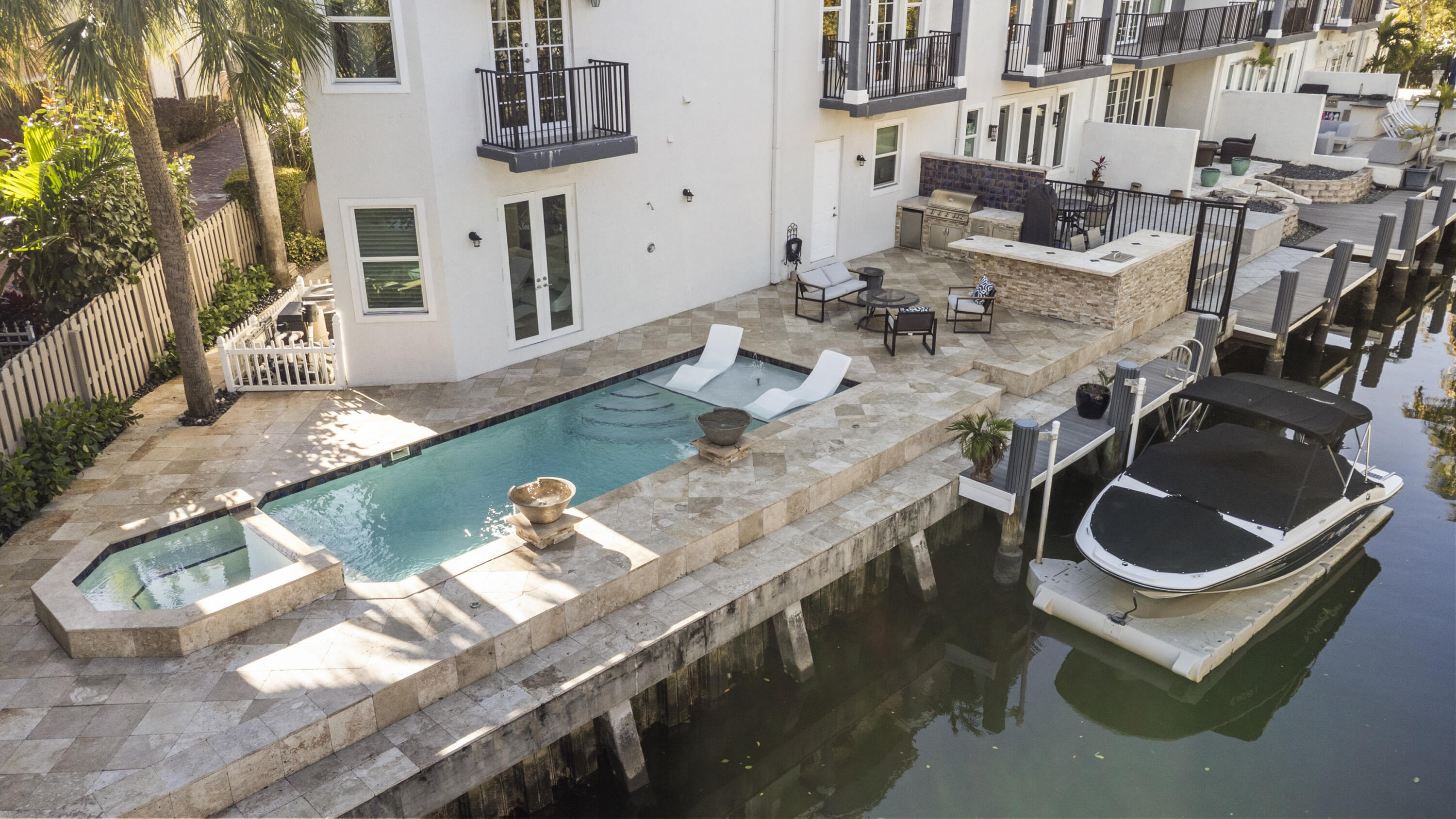 Rarely available gated end-unit townhome, ideally located just one block from Las Olas Boulevard. Positioned on the Himmarshee Canal with 75 feet of private waterfront, a deeded low-maintenance dock, and quick access to the Intracoastal, the home offers beautiful water views throughout.  Inside, soaring ceilings, expansive high-impact windows, marble floors, and whole-home surround sound system enhance the light-filled interior. The layout features 3 bedrooms and 3 full bathrooms, including a spacious owner's suite.  Outside, a private tropical retreat features a full-size pool and spa with fountains, summer kitchen, spacious outdoor living area, and three private balconies overlooking the canal.  A two-car garage, gated driveway with additional parking, and a walkable location near Fort Lauderdale's best restaurants, shops, and nightlife complete this exceptional property.