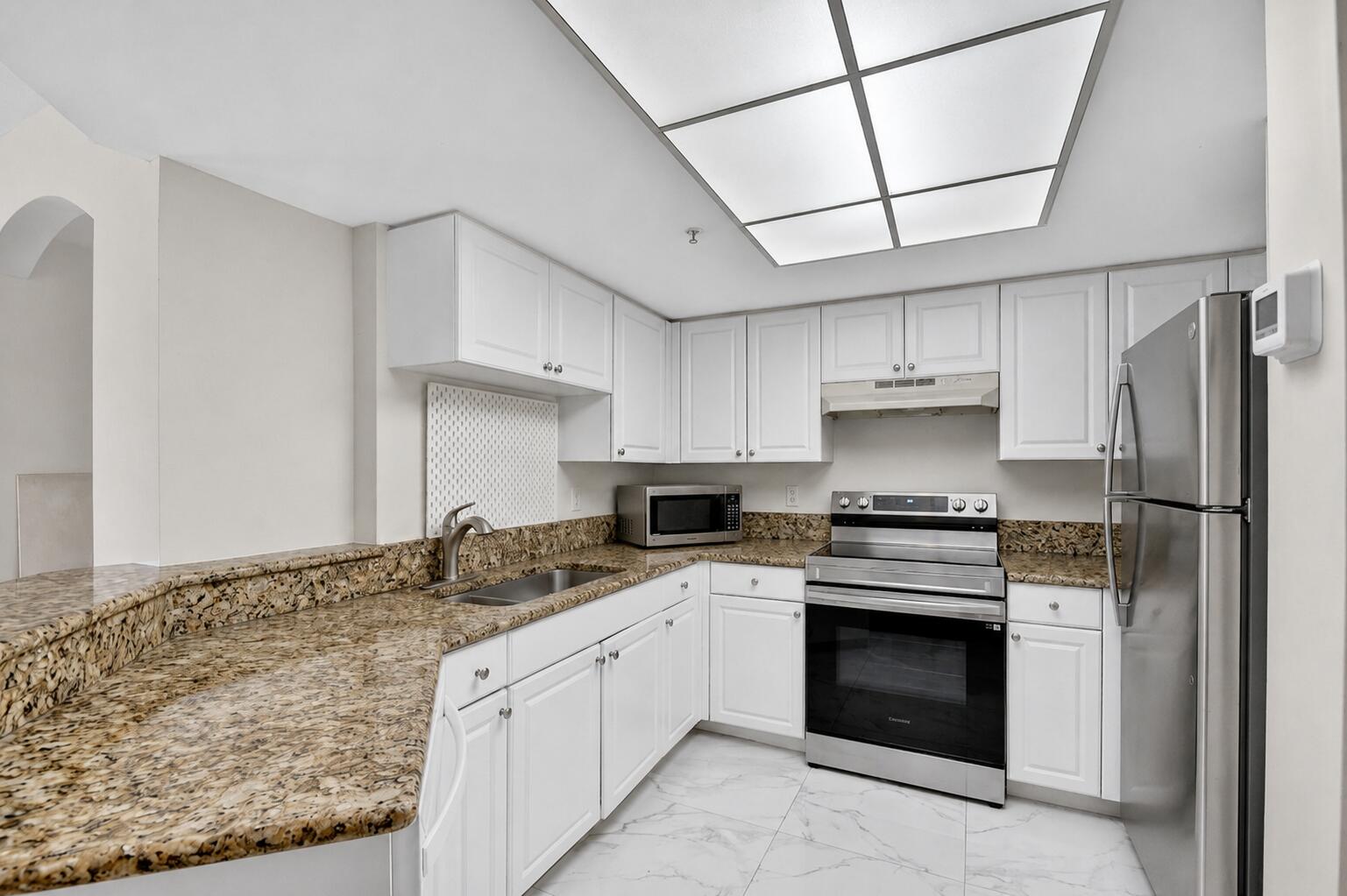 Vacant! Beautifully updated and move-in ready 2-bedroom corner condo in the highly desirable Grandview at Crestwood community. Features brand-new flooring in both bedrooms, a brand-new refrigerator, and fully renovated upscale bathrooms. Bright open floor plan with vaulted ceilings, split-bedroom layout, and a private balcony. Both spacious primary suites include walk-in closets, while the kitchen offers granite countertops and ample storage. Residents enjoy resort-style amenities including two pools, tennis courts, a fitness center, and scenic walking trails. HOA covers water, building insurance, and exterior maintenance. Roof replaced just a few years ago. Prime location just one block from Wellington and minutes from world-renowned equestrian venues, shopping, dining, and entertainment.