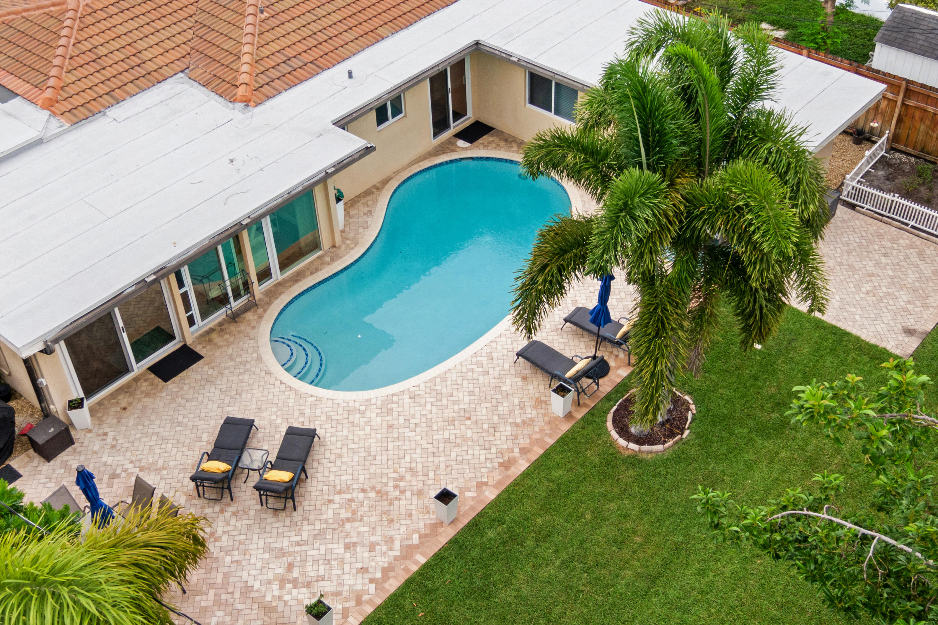 Discover this beautifully maintained 3-bedroom, 2-bath pool home in the highly sought-after Imperial Point neighborhood, where a bright open floor plan, heated pool, full impact windows and doors, and an expansive backyard create the perfect setting for South Florida living. Natural light fills the spacious interior, where beautiful oak flooring flows throughout the main living areas. A cozy living room opens to an expansive family room highlighted by a dramatic wall of sliding glass doors overlooking the heated pool and oversized backyard, creating a seamless connection between indoor and outdoor living. Charming architectural details, including graceful archways and French doors, add warmth and character throughout the home. The well-appointed kitchen is centrally located for effortless entertaining, while the generous dining area easily accommodates a large dining table and sideboard for gatherings with family and friends. The spacious primary suite is a true retreat with direct access to the backyard, a flex-space ideal for a home office, sitting area, or vanity, and a luxurious ensuite featuring dual vanities, a large walk-in shower, private water closet, and a custom walk-in closet with built-ins plus a second closet for exceptional storage. The third bedroom offers its own private exterior entrance, making it ideal for guests, extended family, or a home office. A dedicated interior laundry room adds everyday convenience. Outside, enjoy your own private backyard oasis with a heated pool featuring LED lighting, a massive fully fenced yard, multiple outdoor gathering spaces, a charming front courtyard porch, mature privacy landscaping, and plenty of room to relax or entertain. Additional highlights include a new roof (2022), full impact windows and doors, two A/C systems (2025 & 2022), a spacious 2-car garage, exterior storage closet, complete rain gutter system, automatic irrigation with rain sensor, and two backyard access gates. Imperial Point is a walkable and welcoming Fort Lauderdale neighborhood famous for its street lights and sidewalks. Quiet streets, mature trees, and a strong sense of pride make it easy to feel at home. Primarily made up of single-family homes, many with updated interiors and generous lot sizes, its walkable layout encourages everything from morning strolls to evening dog walks. Just half a mile to the local Publix Supermarket and Holy Cross Hospital, just minutes away. Quick access to 2 beaches. Just 2 miles to Lauderdale By The Sea Beach & 2 miles to the New Pompano Beach, fishing pier, new restaurants, and luxury waterfront dining. Just minutes away are top-rated schools, including Pine Crest School, Westminster Academy, Bayview Elementary (A-rated), Floranada Elementary, and Cardinal Gibbons High School. For travelers and commuters, you'll have easy access to US-1 and I-95. FLL Int'l Airport is 20 minutes away, Miami Int'l Airport is 45 minutes away, and Palm Beach International Airport is 40 minutes away.