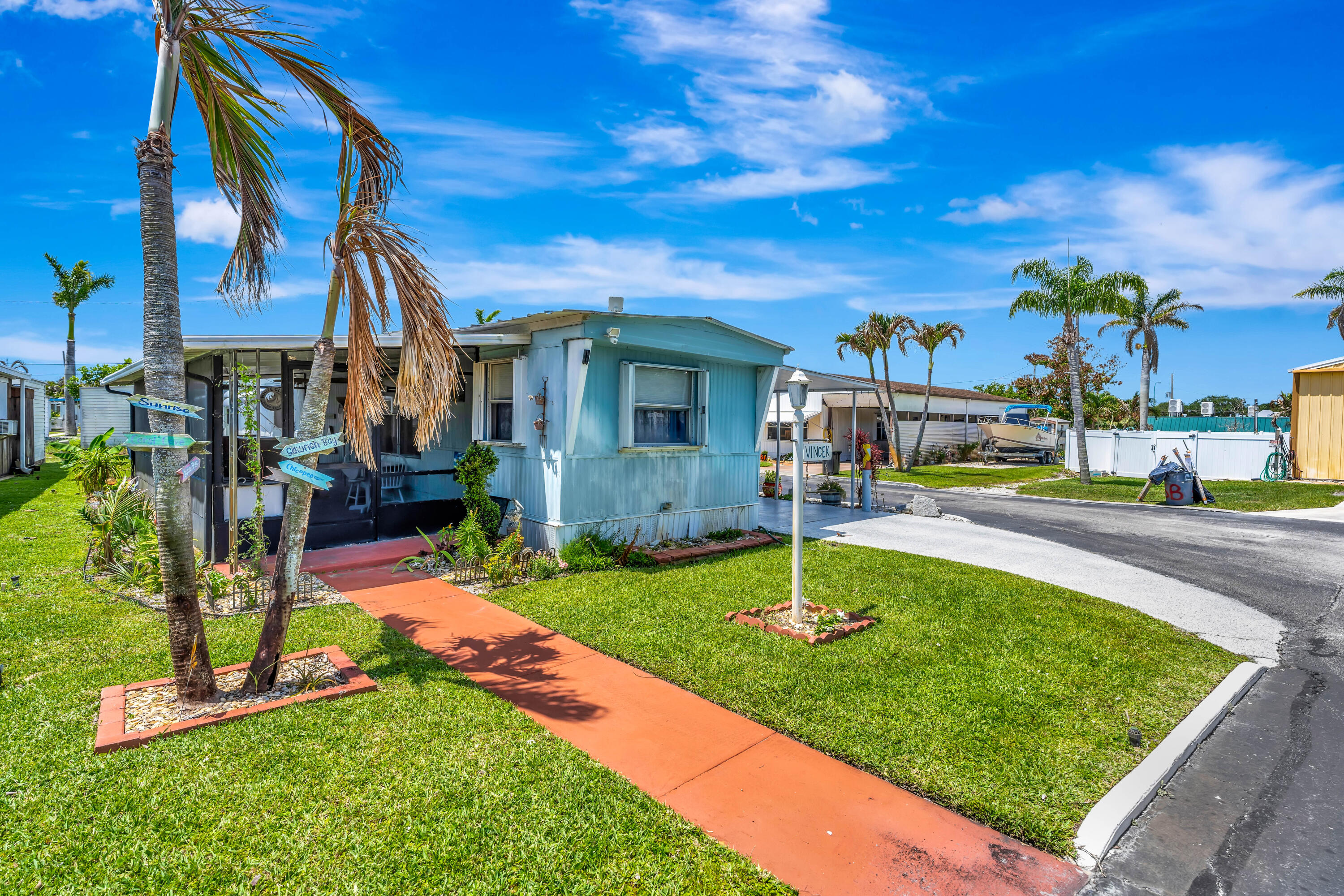 Welcome to Sea Breeze Mobile Manor (55+ Community) where Hobe Sound's best-kept secret meets an unbeatable Florida lifestyle. This fully updated 3-bedroom, 1.5-bath corner lot home is move-in ready in every sense of the word. Furniture, TVs, beds, washer, dryer, office desk included. Truly just unpack and enjoy. Inside you'll find all new kitchen cabinets, countertops, and appliances, solid new flooring throughout, a walk-in shower, and a newer oversized AC keeping things cool all year. Outside, the decorative flake driveway, attached carport, and utility shed check every practical box, while the screened patio with a custom built-in bar is where the real living happens. The corner lot gives you breathing room and a peaceful view of the natural park area that most units simply can't offer.
