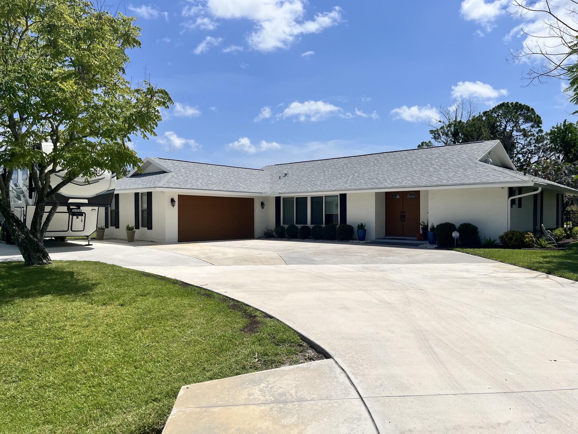 Nestled on one of the largest lots in the area at an expansive .63 acre, this stunning 4 BR, 3 BTH home delivers the space and lifestyle that Florida life is all about. Fully fenced & beautifully landscaped, the grounds are as impressive as the home itself, with mature fruit trees, lush lawn, & room to breathe that simply can't be found in newer developments. The open concept kitchen has been thoughtfully upgraded to include a skylight with a retractable shade which floods the space with natural light. The screened lanai adds even more flexible living space year round. Out back, the resort-style pool & sun deck are surrounded by tasteful potted greenery and ample lounging space. Properties like this combining acreage, upgrades, pool and parking versatility are rare on the Treasure Coast.