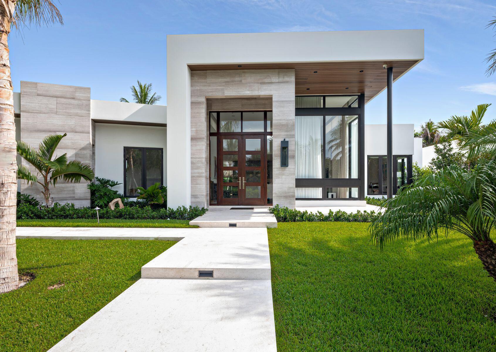Offered for the first time, this exceptional 2023 custom-built estate showcases sophisticated one-story living with 5 bedrooms, 4 full baths, 1 powder bath, and 3,713 square feet under air (3,899 total square feet). Meticulously designed with no detail overlooked, the residence blends modern elegance with premium craftsmanship throughout. Soaring ceilings, designer finishes, motorized window treatments, and thoughtfully curated materials create a refined yet comfortable living environment. The stunning chef's kitchen is appointed with exquisite Naturali Calacatta Michelangelo Lucidato polished porcelain countertops, which are also featured in the primary bath and powder room. Beautiful Caliza Capri polished limestone flooring flows throughout the home, enhancing the bright, contemporary  aesthetic. Indoor and outdoor living seamlessly converge with a spectacular 475-square-foot covered tiki-hut entertaining area overlooking the heated saltwater pool—an ideal setting for year-round relaxation and entertaining. Additional features include a Kohler 48KW whole-house generator, providing peace of mind and uninterrupted comfort. Ideally located near area beaches, the Flagler Drive waterfront bike trail, acclaimed dining destinations, world-class shopping on Worth Avenue, and the pristine shoreline of the Atlantic Ocean, this extraordinary residence offers a rare opportunity to enjoy luxury coastal living at its finest.