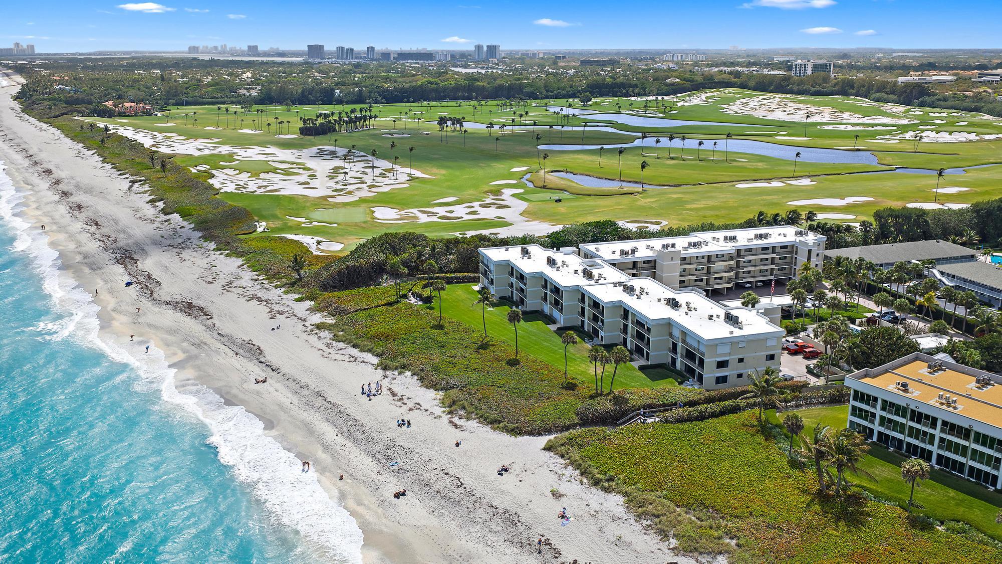 Just steps from the sand, this beautifully updated 2 bed + office/den or additional bedroom, 2 bath condo  located in the coveted Royal Homestead building is ready for you, complete with 2 garage parking spaces. This light-filled, coastal inspired residence features 10' ceilings, newly updated wood flooring, fresh interior paint, and a thoughtfully designed layout perfect for both everyday living and entertaining. The spacious living area showcases a custom wet bar with shaker-style cabinetry and wine refrigerator, creating an inviting space to host guests. Enjoy ocean breezes from both the primary and main living area balconies, bringing the best of Juno Beach living right to your doorstep. Both en-suite bedrooms offer newly built-out walk-in closets and beautifully renovated bathrooms. Impact sliding doors and roll-down shutters provide full hurricane protection. Additional features include a private storage closet, heated community pool, clubhouse, guest cottage for owner use and private gated beach access. The building also features a new roof adding additional peace of mind for residents. This exclusive 55+ beachfront community is ideally located directly next to the world-famous Seminole Golf Club and just minutes from the dining, shopping, and lifestyle attractions of Jupiter and Palm Beach Gardens. Bring your beach chair and experience the relaxed elegance of true oceanfront living in one of Juno Beach's most desirable communities!