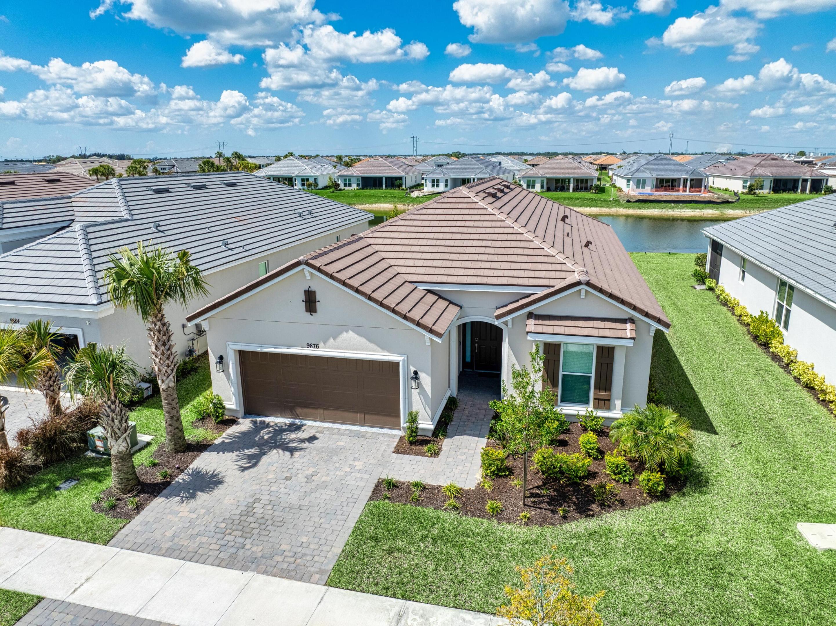 MOVE IN READY AND NO UGLY POWER LINES! $17,000 HOT TUB AVAILABLE TOO! Welcome to this beautifully appointed 3-bedroom, 3-bath home with a versatile den, located in the highly sought-after Esplanade at Tradition. This home is perfectly positioned to capture a stunning, serene lake view with spectacular sunsets, offering the ideal blend of luxury and comfort. Featuring a durable tile roof and full impact windows, this residence provides both style and peace of mind. Inside, you'll find a spacious open-concept layout where the living, dining, and kitchen areas flow seamlessly together—perfect for entertaining or everyday living. The heart of the home is the expansive kitchen, complete with a massive center island, gas range, and ample cabinetry—ideal for cooking and gathering.   The oversized primary suite is a true retreat, offering generous space, a large walk-in closet, and a spa-like bathroom with dual sinks and an upgraded walk-in shower. Two additional bedrooms provide comfort and privacy for guests, including one with its own en-suite bathroom. The enclosed den with doors offers flexibility for a home office, media room, or additional guest space. Enjoy peaceful mornings and breathtaking sunsets overlooking the lake from your private outdoor space. This home truly combines thoughtful design, high-end features, and an unbeatable location.