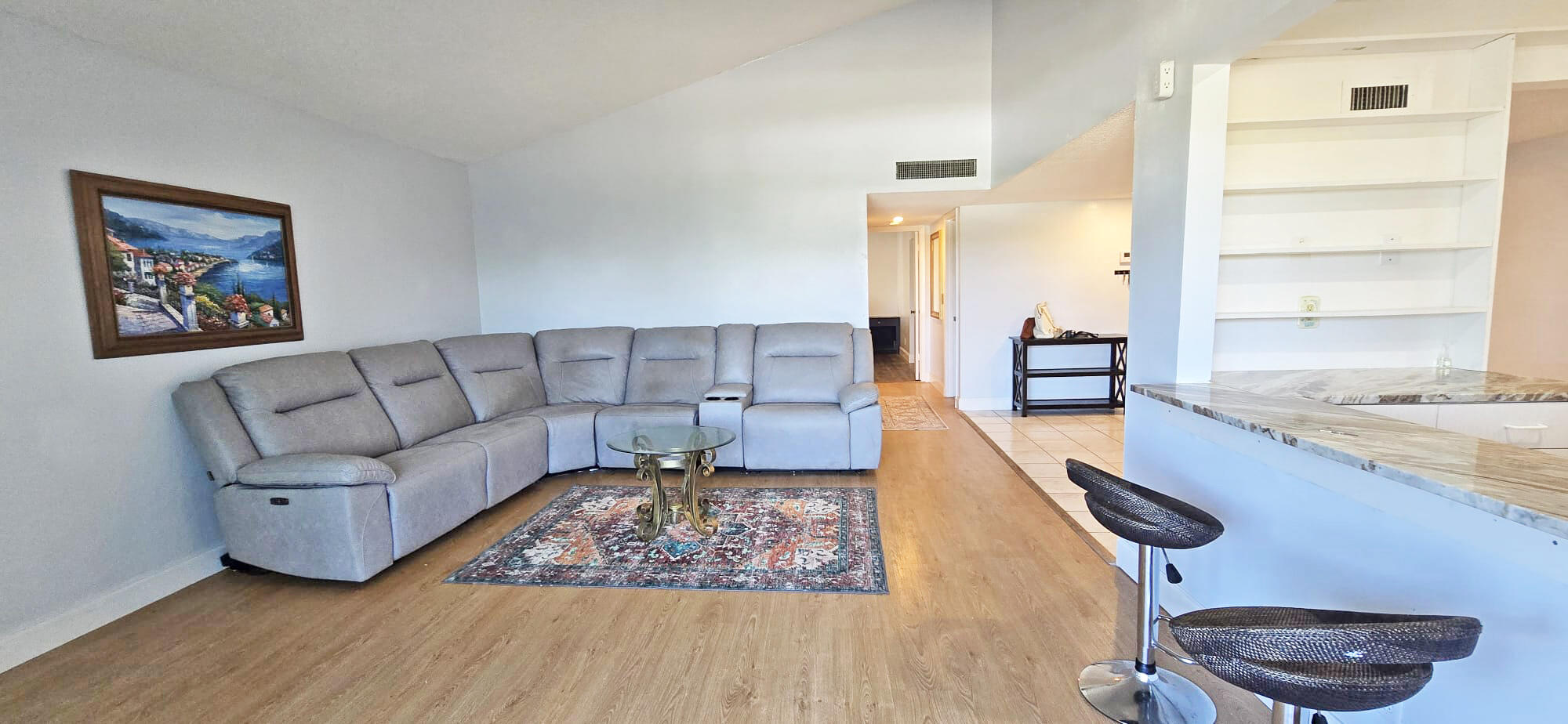This beautifully 55+ well maintained 2-bedroom, 2-bathroom second-floor condo offers comfort, style, and peace of mind with a new A/C, an 18-month-old water heater, hurricane shutters, and a recently replaced roof. Neutral flooring and a vaulted ceiling create an open, airy feel, while the flowing layout connects the living and dining areas seamlessly. The kitchen includes a convenient snack bar perfect for casual meals. Enjoy the screen-enclosed balcony, ideal for morning coffee or relaxing outdoors. Ideally located near shopping, dining, Palm Beach International Airport, downtown West Palm Beach, and Lake Worth Beach, this condo offers exceptional convenience for a primary residence or vacation retreat.