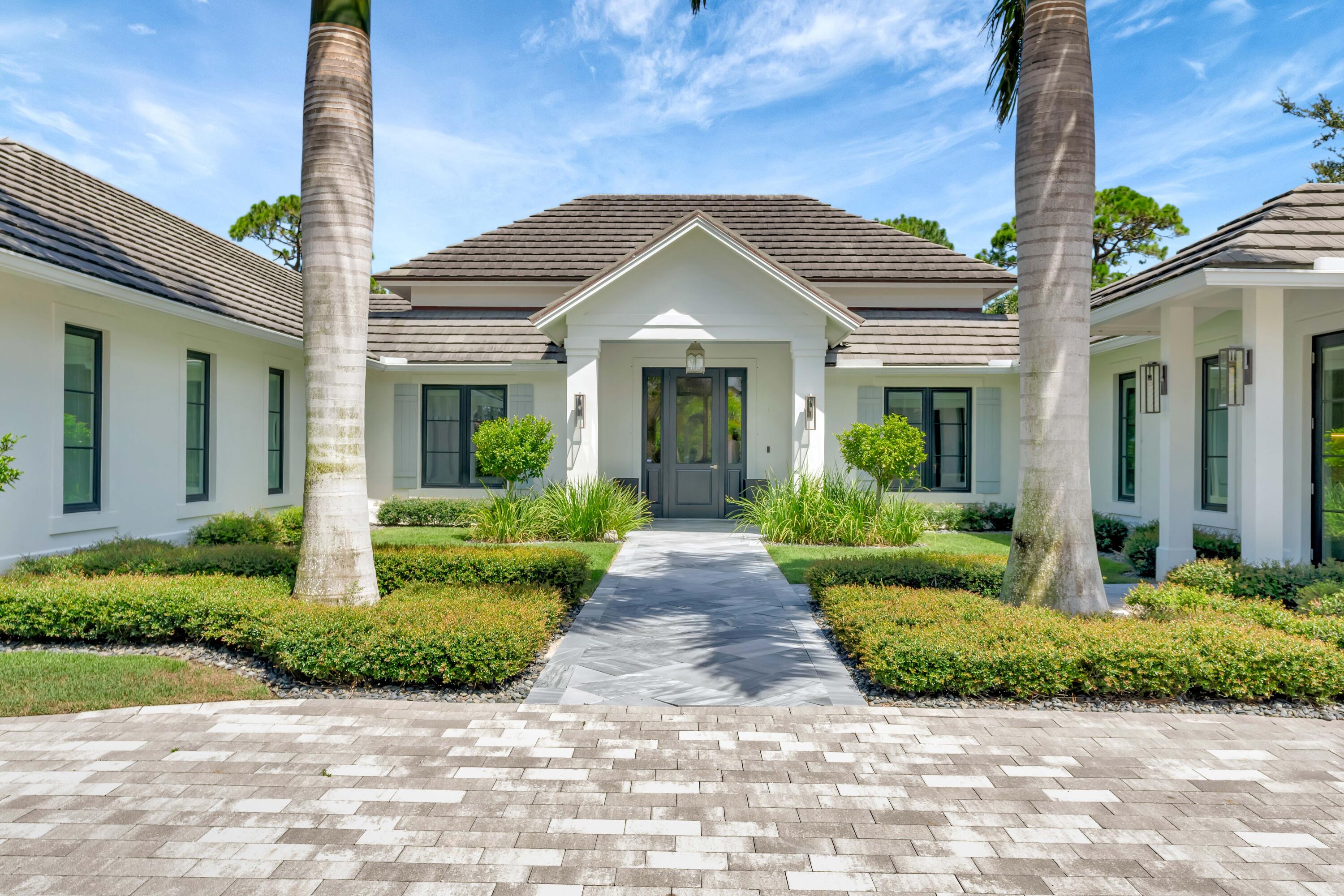 Located in the prestigious community Loblolly Pines, lies this beautifully crafted estate home built in 2019. Designed by architect Scott Baruch & Associates and sited on one of the premiere lots, this custom built residence has endless        features and does not disappoint. Attention to detail was paramount in constructing this four bedroom, four and two half bath home with a bright open floorplan, pristine mill work, vaulted and coffered ceilings, hurricane rated impact         windows and doors throughout. Inside you will find continuous wood-look tile floors, an open kitchen with custom cabinetry and leathered quartzite countertops, an appliance garage, stainless steel and paneled Thermador appliances and a generous bar area with Sub-Zero wine refrigerator with drawers, dishwasher a and icemaker. Oversized stacked sliders welcome you to the spectacular open lanai and summer kitchen, where you can enjoy majestical views of the pool and spa and let the outdoors in.
The primary suite encompasses over 600 Sq. Ft. with seating area, walk-in his and her closet, bathroom featuring an oversized frameless glass shower that is joined by a beautifully tiled outdoor shower, floating contemporary cabinetry and quartz top double vanity. The ample guest suite is accessible through it's own private entrance and is warm and inviting. All bedrooms are beautifully appointed and enjoy built-in closets and ensuite baths.
