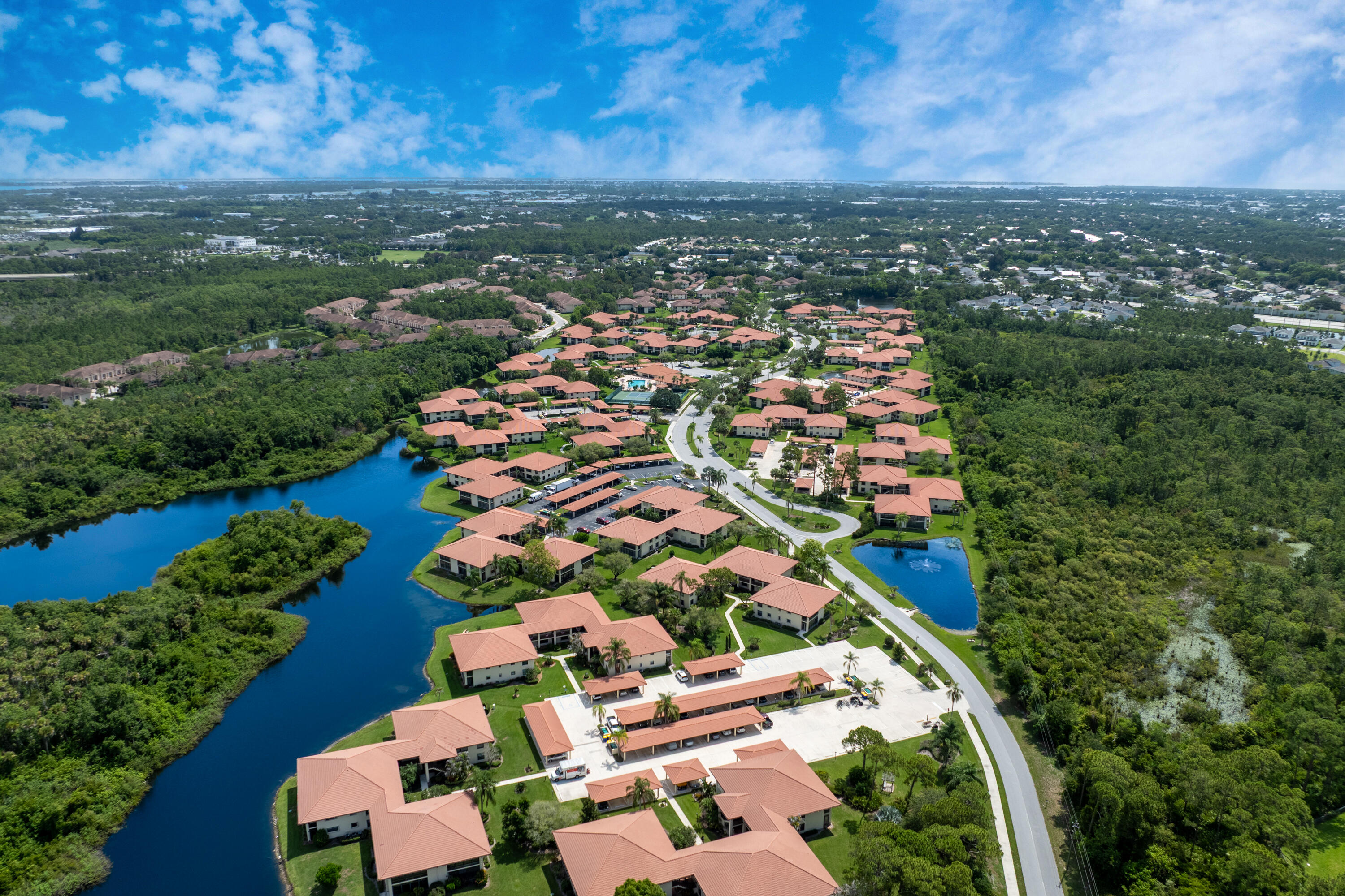 Enjoy the ease of one-level living in this well-maintained first-floor corner condominium featuring two bedrooms and two full baths. The spacious living and dining areas offer an open, inviting layout, complemented by durable vinyl flooring throughout and tile flooring in both bathrooms. The kitchen is designed for both function and style with abundant cabinetry, stainless steel appliances, and a large pass-through opening that enhances the open-concept feel. Recent updates include a new stove and vent hood (2026), garbage disposal (2025), refrigerator (2024), dishwasher (2022), new AC condenser coil (2026), and stackable washer and dryer (2020). Relax in the enclosed porch, complete with a generous storage room and convenient access from both the living room and each bedroom.  The primary suite features a large walk-in closet and an updated bath with a walk-in shower. Additional highlights include hurricane accordion shutters and a covered parking space. Ideally situated directly across from the clubhouse and pool, this move-in-ready "B" floor plan is one of the community's most desirable designs. South River Condos is an active 55+ community offering resort-style amenities, including a clubhouse, swimming pool, tennis and pickleball courts, RV and boat storage, library, billiards room, card room, woodworking shop, shuffleboard, bocce ball, horseshoe pits, grilling areas, and a full calendar of social activities.