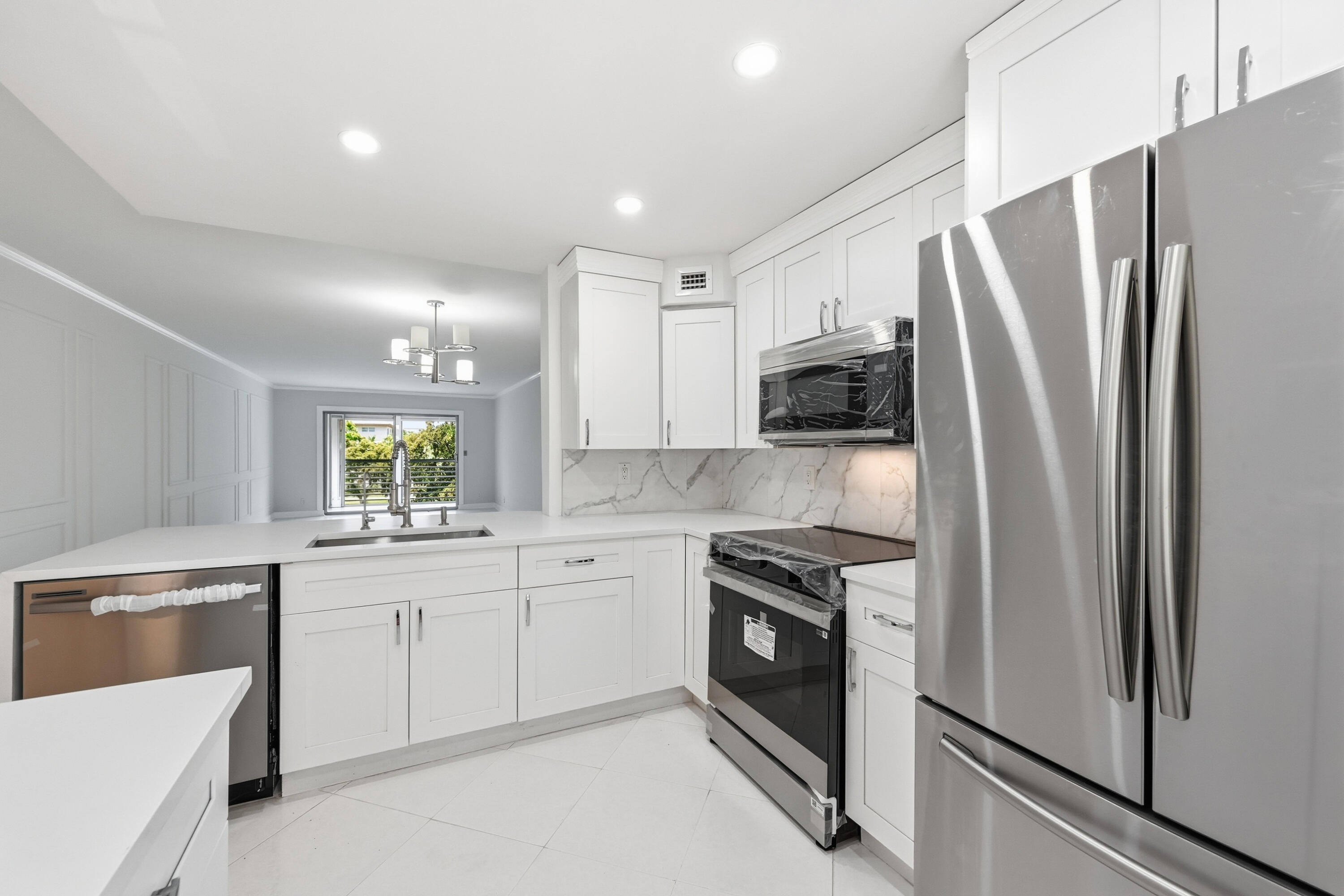 Stunningly remodeled 2bedroom/2bath condo located in the sought-after Wynmoor Village 55+ community! This beautifully updated residence features an open-concept kitchen with newer cabinetry, elegant quartz countertops, and stainless-steel appliances, creating the perfect space for entertaining. Gorgeous porcelain flooring flows throughout the entire unit, complemented by ceiling fans in every room for added comfort. Both bathrooms have been tastefully renovated with luxury porcelain-tiled showers, modern vanities, and stylish finishes. Relax and enjoy serene lake and fountain views from the screened and decorated balcony for full year-round enjoyment. New A/C (2026). Resort style Community with no extra fees: pickleball, tennis, etc. Move in ready!