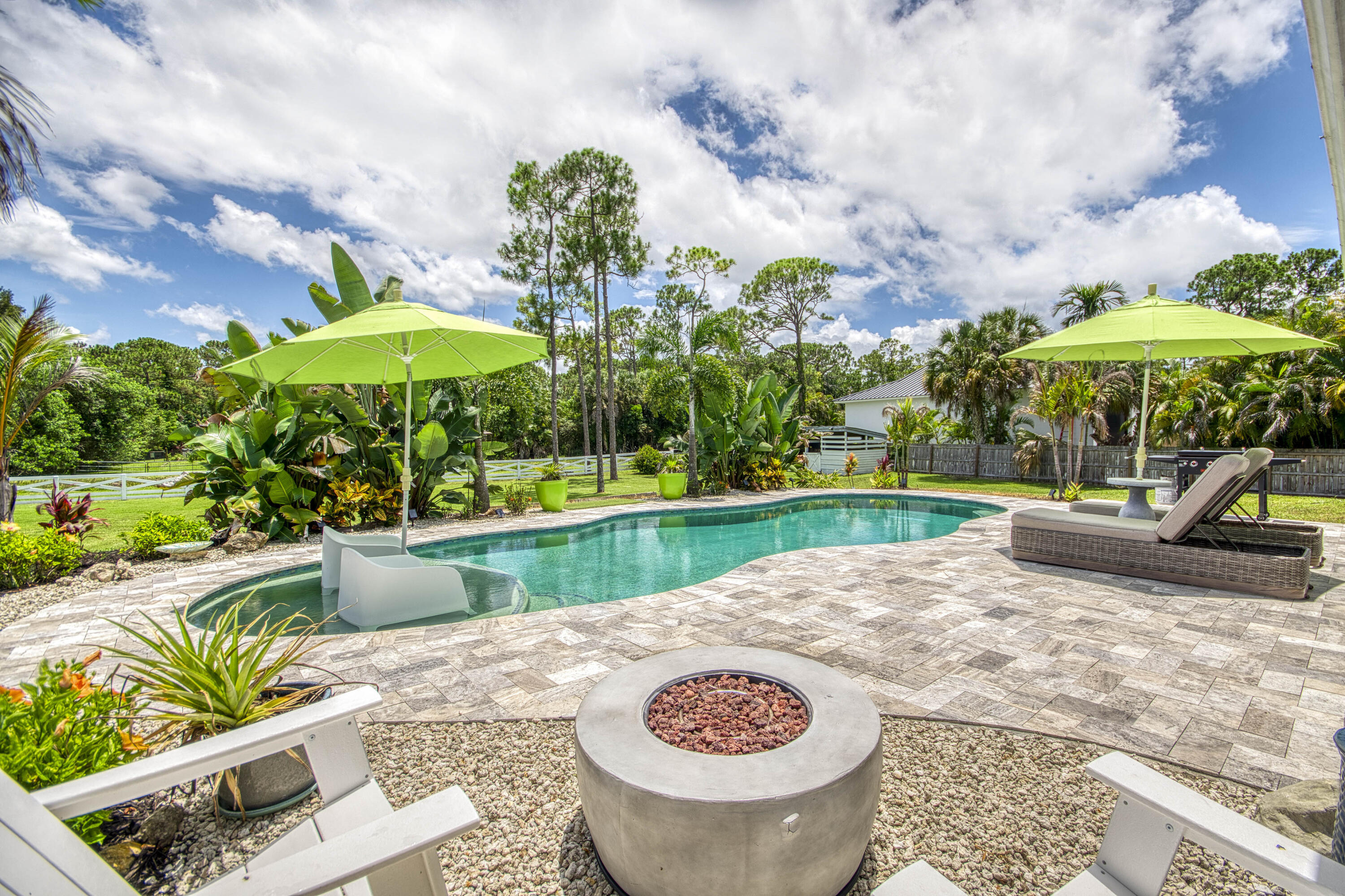 Set on 1.25 private acres, this impeccably maintained 2BR/2BA in a non-HOA area delivers the space, freedom, and lifestyle buyers are searching for. Just minutes from Downtown West Palm, pristine beaches, dining, and shopping. Designed for both relaxation & entertainment, the backyard is a private tropical retreat w/a newer saltwater pool, lush landscaping, and a fully fenced yard. Inside, the home reflects pride of ownership throughout, with thoughtful improvements and meaningful upgrades that enhance both value and everyday living. Car enthusiasts, hobbyists, and entrepreneurs will appreciate the oversized 720 sq ft attached garage, while the additional barn offers exceptional storage and versatility. Combining usable acreage, substantial improvements, privacy, and an unbeatable location, this move-in-ready property presents a rare opportunity to enjoy Palm Beach County living without HOA restrictions.