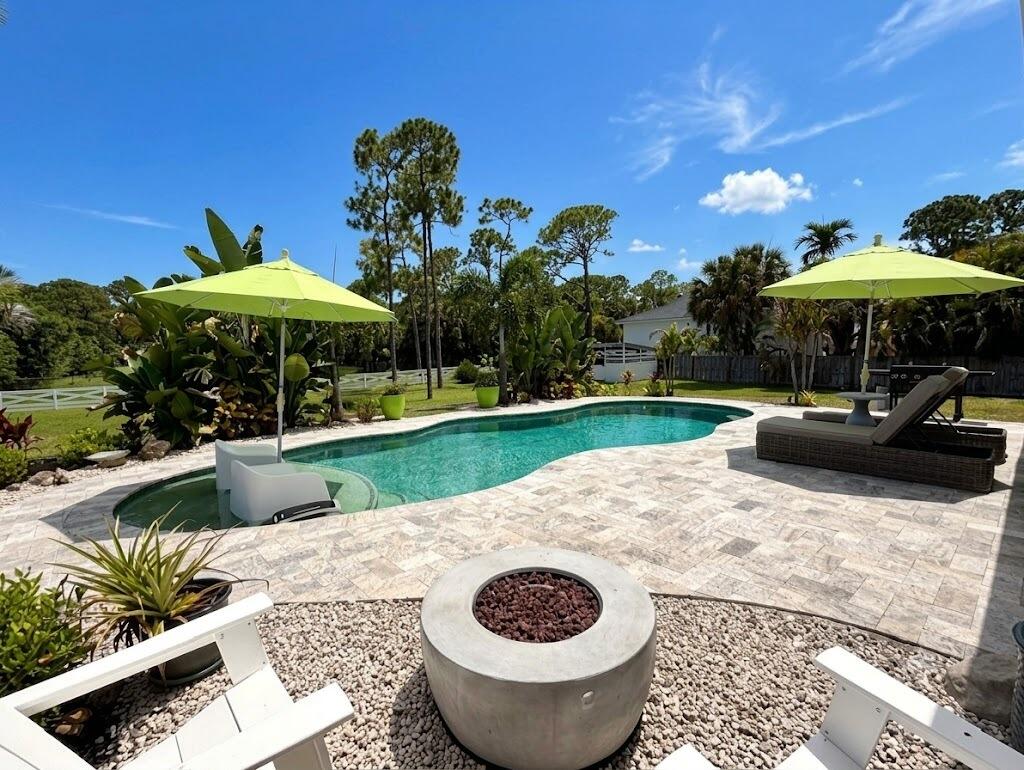 Set on 1.25 private acres, this impeccably maintained 2BR/2BA in a non-HOA area delivers the space, freedom, and lifestyle buyers are searching for. Just minutes from Downtown West Palm, pristine beaches, dining, and shopping. Designed for both relaxation & entertainment, the backyard is a private tropical retreat w/a newer saltwater pool, lush landscaping, and a fully fenced yard. Inside, the home reflects pride of ownership throughout, with thoughtful improvements and meaningful upgrades that enhance both value and everyday living. Car enthusiasts, hobbyists, and entrepreneurs will appreciate the oversized 720 sq ft attached garage, while the additional barn offers exceptional storage and versatility. Combining usable acreage, substantial improvements, privacy, and an unbeatable location, this move-in-ready property presents a rare opportunity to enjoy Palm Beach County living without HOA restrictions.