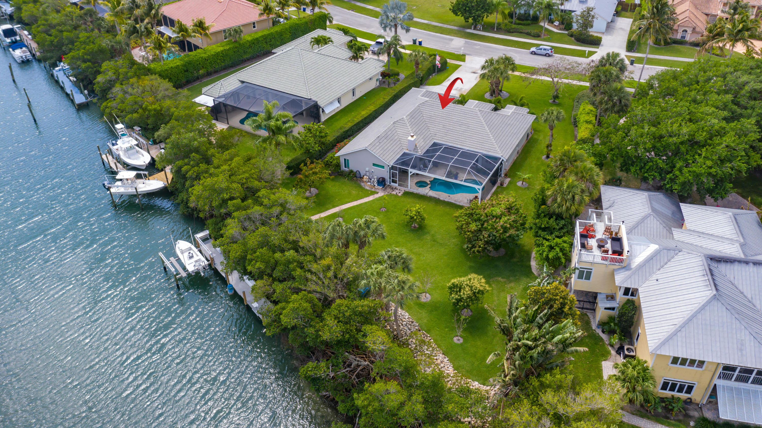 Enjoy exceptional coastal living in this well maintained waterfront residence on sought-after Hutchinson Island. The home offers stunning views of the pool, private dock, and the Intracoastal Waterway. Inside, you'll find soaring 14-foot vaulted ceilings, an open floor plan with 4 bedrooms/3 baths, porcelain tile flooring, granite countertops, plantation shutters, and elegant arched windows. Equipped with Diamond PPG hurricane-impact windows with a lifetime warranty and generous yard space for outdoor enjoyment. The 48 ft dock includes an 8 ton lift making this a boaters paradise! New HVAC 2023, Generac generator!  Just two miles to inlet and within walking distance to the beach, this property delivers the best of Florida waterfront living! Sold as is.