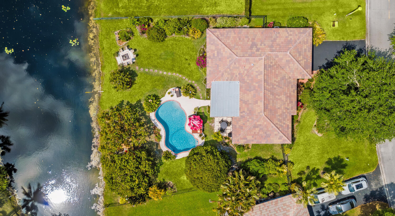 Very walkable location which is unusual for western  S FL.  It's a 6 min walk to Eddie & Vinny's Coastal Italian on Sample Road. City Hall grandstand parties, CVS, Chabad Lubavitch and other places of worship, groceries and a plethora of other restaurants and cafes are nearby.  Almost 1/3 acre of beautifully landscaped private yard on a wide lake in a great friendly quiet well maintained neighborhood. Multimillion dollar houses across the street. No HOA!  Jog or walk the paths under the shade of the canopy of Oak trees, even in the summer. Fire pit area, as well as breezy hammock and dining areas under the mango and avocado trees. Lemon and lime trees too! Lighted kidney shaped pool for evening ambience. Screened in porch. Garden of the month 2024. Fish from the backyard!   Split floor plan currently used as a 3/2 plus office.  House was initially built as a split 3/2 with an open family room off of the kitchen, previous owners closed the family room into a 4th BR, which is currently used as an office with double French doors, but can easily and inexpensively be turned back into either a 4th bedroom or open family room.  OPTIONS for minimal $!   Ensuite primary with walk in closet and double sinks. Updated with warm and inviting mahogany finishes, open entertainers kitchen, 20" diagonal tile throughout. Solid wood kitchen cabinetry, tier 3 granite, Brazilian Santos Mahogany butcher block, Pottery Barn light fixtures and vanities. Custom ironwork. Living room, patio and primary bath wired for sound system, patio and bath speakers stay. Double garage with Craftsman work bench with shelves included. LOW OVERHEAD MAINTENANCE - Current low affordable private insurance rate due to new roof (2023/24) and roof to wall hurricane straps as well as complete hurricane impact windows and doors. NOT in a FEMA flood zone! Huge savings in water bills as new irrigation pump pulls water from the lake. New attic insulation and ductwork/vents for low A/C rates.  Large yard for possible expansion - buyer must due own diligence. Playground almost across the street, parks, hockey rink, tennis club and Sawgrass Expressway are minutes away. Upgrades within the last few years - pool pump, filter and vacuum, attic insulation and ductwork, tiled ROOF and flat roof, gutters, W/D, D/W, irrigation pump, patio screens and high lockable lanai safety door to pool, etc... Fenced in on 3 sides with keyed locks. The pool has holes surrounding it from a previously installed child safety fence.  Please note that home showings will be recorded.