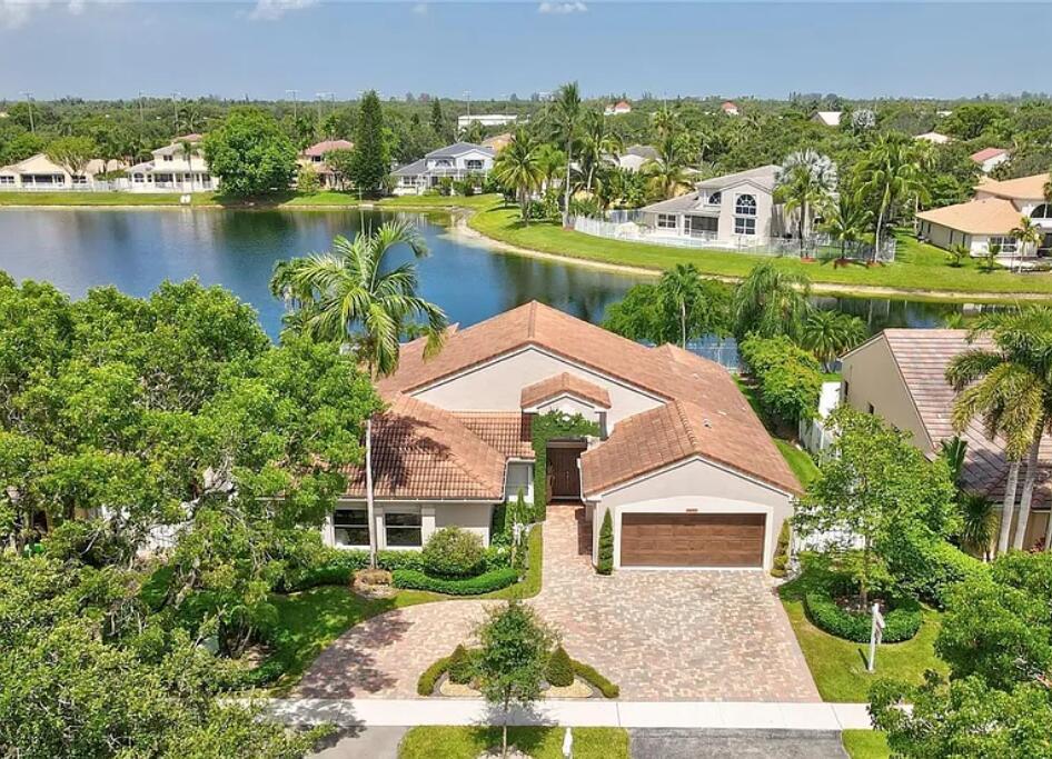 Rare opportunity to own a fully renovated waterfront home in the gated community of Shannon Lake Estates. This exceptional single-story residence offers 4 bedrooms, 2.5 baths, and stunning water views. Extensive updates include a new flat tile roof (2026), impact windows and doors (2026), garage door (2026), updated appliances, HVAC (2022), and a Tesla charging station. The chef's kitchen features custom Italian cabinetry, granite countertops, and an oversized island. Porcelain flooring flows throughout the home. Enjoy South Florida living with a sparkling pool, expansive patio, and tranquil waterfront setting. Conveniently located near Sawgrass Mills, dining, entertainment, and American Heritage Schools.