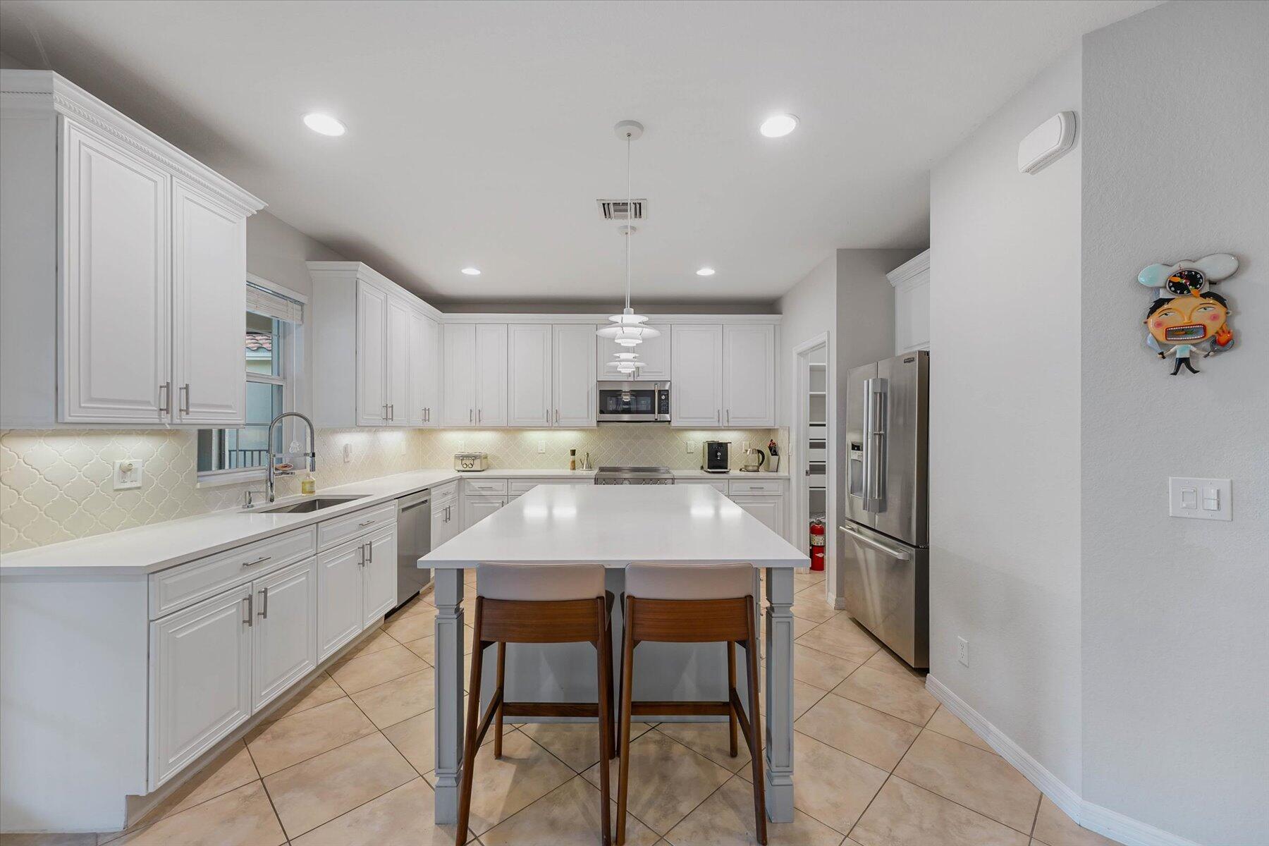Enjoy your seasonal stay in this beautifully maintained 4-bedroom, 2.5-bath home located in a desirable gated community with a fitness center and community pool. One bedroom is set up as a home office, making it ideal for remote work or extra space.  The open-concept layout features a spacious kitchen with top-of-the-line appliances, a large island, and plenty of room for entertaining. Step outside to your private fenced backyard with a heated pool, tranquil water views, and a covered patio complete with lounge seating and an outdoor dining area.  A perfect blend of comfort, convenience, and Florida living.