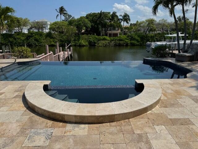 One of a kind Admiralty home, unique in layout and size, 3307 sq. ft. The screened-in porch has been pushed out with Impact glass doors, Every room has been customized. Southeast exposure, dockage for up to 42 foot boat. Large patio with rare black infinity pool with matching black hot tub and fiber optic lights. Hidden rock speakers and custom landscape lighting. Living room and family room are open, airy floor plan with travertine marble gas fireplace. Sub zero refrigerator, extra large breakfast bar, pantry & black granite counters. Laundry room doubles as hurricane room with double walls, double ceiling & floor drain, giving you a 'safe place'' during storms.  Hurricane impact glass windows. 13 year old roof and skylights. Garage has built-in closet and overhead storage. Don't miss seeing this distinctive home in the private community of Admiral's Cove. Square footage represented in this listing is taken from recent floor plan prepared by a professional in the field, and may differ from square footage in tax rolls. Information is deemed reliable, but not guaranteed.