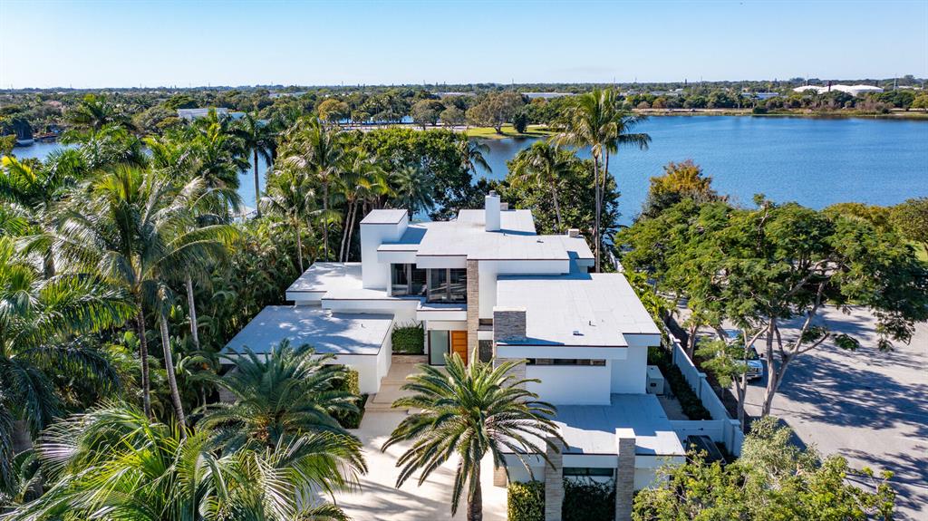 Luxe Frank Lloyd Wright-inspired estate, on almost an acre with 110+/- feet fronting Lake Ida, offers striking architecture, an incredible setting, and a premier Delray Beach community, which combine to create an unparalleled South Florida lifestyle opportunity. Perfect for water-sports enthusiasts are a boat house and dock, and inviting indoor/outdoor entertaining, two loggias overlook the pool.The information herein is deemed reliable and subject to errors, omissions or changes without notice.  The information has been derived from architectural plans or county records. Buyer should verify all measurements. 1080 Lake Dr., Delray Beach, Florida: Minutes from the beach and vibrant downtown Delray Beach, the desirable Lake Ida neighborhood, a community studded with mature trees and verdant landscaping, is a peaceful oasis centered on a picturesque lake offering boating and fishing. Close by are two lakefront parks, one home to the Delray Beach Playhouse.

PROPERTY:
 
In a world of its own, set back on almost an acre off of a private cul-de-sac in the prestigious Lake Ida neighborhood, a brick-paved driveway leads through tropically landscaped grounds to the motor court and three-car garage. In the back, an expansive lawn extends down to 110 +/- feet of Lake Ida waterfrontage, where a boat house and full-service dock make this estate perfect for boating and water-toy enthusiasts. Inviting indoor/outdoor living, an open-air loggia and a screened loggia with a summer kitchen overlook the lake-view heated salt-water pool.

RESIDENCE:  

Presenting as a tour-de-force reminiscent of Frank Lloyd Wright's unmistakable panache, the façade of this Randall Stofft-designed masterpiece is set off with impressive stacked-stone columns and banks of sliding doors topped with bands of clearstory windows, bathing the interiors with luxuriant ambient sunlight and offering lake and garden views. Under a canopy of banyans and set within lovely landscaping dotted with palm trees, the stunning Contemporary-Mid-Century-style, five-bedroom estate, with 7,353 +/- total square feet, was designed to elicit a light-filled breezy vibe and chic sophisticated sensibility, with details that include high ceilings, terrazzo and new wood flooring, new LED lighting, and a new wine room, complete with its own cooling system and stacked-stone finishes. The foyer, modernistic stairwell, and handsome stacked-stone embellishments provide an impressive entry point to the living room, with a welcoming wood-burning fireplace, and just adjacent are the dining room, bar, and kitchen, finished with contemporary custom-wood cabinets, Dekton counters with a leather finish, tile backsplash, professional-grade appliances, and large island accommodating seating. With a split-bedroom plan for privacy, double doors off the living room lead to the primary bedroom with floor-to-ceiling windows offering lake views. The suite includes two custom-fitted closets and a spa-inspired bathroom. Upstairs, a loft and morning bar access the large lake-view balcony and serve two ensuite guest bedrooms. Off of the dining room, a separate entrance with its own staircase leads up to the guest apartment, comprising a bedroom and an office/bedroom that accesses a sun deck. Other details of note: a new roof was installed in 2020, and full-house generator was installed in 2021.

DISCLAIMER: Information published or otherwise provided by the listing company and its representatives including but not limited to prices, measurements, square footages, lot sizes, calculations, statistics, and videos are deemed reliable but are not guaranteed and are subject to errors, omissions or changes without notice. All such information should be independently verified by any prospective purchaser or seller. Parties should perform their own due diligence to verify such information prior to a sale or listing. Listing company expressly disclaims any warranty or representation regarding such information. Prices published are either list price, sold price, and/or last asking price. The listing company participates in the Multiple Listing Service and IDX. The properties published as listed and sold are not necessarily exclusive to listing company and may be listed or have sold with other members of the Multiple Listing Service. Transactions where listing company represented both buyers and sellers are calculated as two sales. The listing company's marketplace is all of the following: Vero Beach, Town of Orchid, Indian River Shores, Town of Palm Beach, West Palm Beach, Manalapan Beach, Point Manalapan, Hypoluxo Island, Ocean Ridge, Gulf Stream, Delray Beach, Highland Beach, Boca Raton, East Deerfield Beach, Hillsboro Beach, Hillsboro Shores, East Pompano Beach, Lighthouse Point, Sea Ranch Lakes and Fort Lauderdale. Cooperating brokers are advised that in the event of a Buyer default, no financial compensation will be paid to a cooperating Broker on the Deposits retained by the Seller. No financial compensation will be paid to any cooperating broker until title passes or upon actual commencement of a lease. Some affiliations may not be applicable to certain geographic areas. If your property is currently listed with another broker, please disregard any solicitation for services. Copyright 2022 by the listing company. All Rights Reserved.