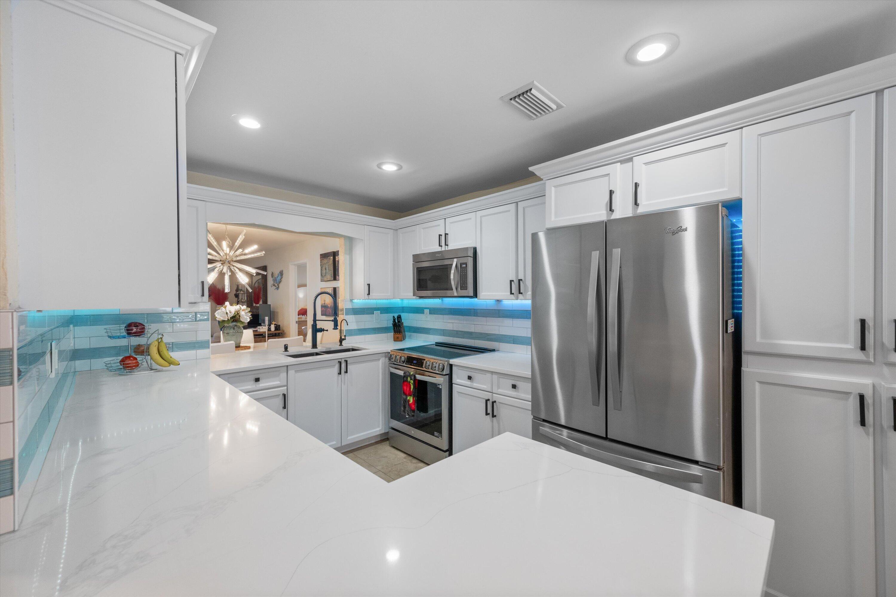 NO HOA! Tucked away on a quiet cul-de-sac in one of Wellington's most desirable neighborhoods, this beautifully updated home offers the perfect combination of privacy, modern upgrades, and South Florida living. Situated on an oversized pie-shaped lot with lush tropical landscaping and beautiful sunrise views from the backyard, this move-in ready property is packed with over $100,000 of improvements both inside and out.  From the moment you arrive, you'll appreciate the dual driveways, manicured landscaping, mature palms, and inviting curb appeal. Inside, the home features spacious living areas filled with natural light, updated flooring, recessed lighting throughout, and a layout designed for living and entertaining. The renovated kitchen is a standout feature, offering granite countertops, custom cabinetry, newer stainless steel appliances, a matching wet bar, and plenty of workspace for cooking and gathering. Multiple living and entertaining spaces flow seamlessly to the screened patio, creating the ideal indoor-outdoor lifestyle. The spacious primary suite offers an expansive walk-in closet and a beautifully remodeled spa-inspired bathroom featuring double sinks, custom finishes, and an oversized walk-in shower.  The guest bathroom has also been tastefully renovated with designer tile, upgraded fixtures, glass enclosures, and enhanced ventilation systems.  Extensive upgrades provide peace of mind, including hurricane-impact windows, doors, and garage door, a newer air conditioning system with electronic filtration, upgraded electrical panel, plumbing improvements, reverse osmosis water filtration system, Nest smart thermostat, WiFi-enabled sprinkler system, WiFi-capable keyless entry, exterior security lighting, new attic insulation, gutters, window coverings, and additional storage with attic access. The Florida porch roof was replaced in 2022, and professional landscaping and pest control services are already in place.  Step outside to the screened patio, where string lighting and tranquil backyard views create the perfect setting for morning coffee or evening gatherings. The expansive yard offers plenty of room for pets, play, gardening, or even a future pool, while the eastern exposure allows you to enjoy beautiful sunrises to start each day.  Located within Wellington's highly sought-after school district and just minutes from world-renowned equestrian venues, you'll love being close to the Winter Equestrian Festival, Saturday Night Lights, shopping, dining, parks, and everything that makes Wellington one of South Florida's most desirable places to call home. If you've been searching for a move-in ready home with no HOA restrictions, extensive upgrades, a spacious primary suite, oversized lot, and prime Wellington location, this is the one you've been waiting for.