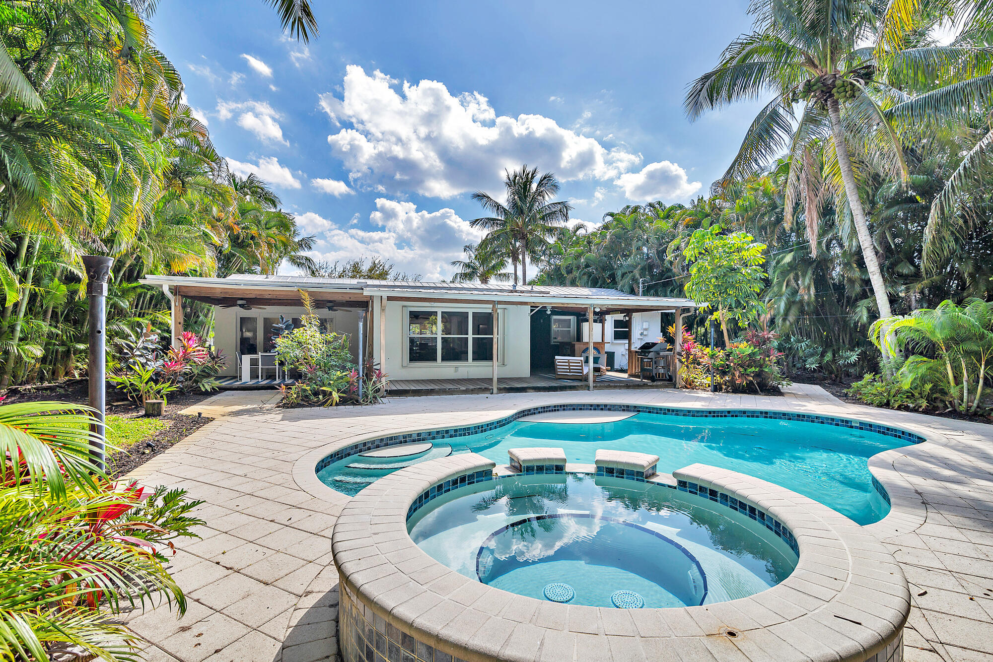 Unwind from the grind! Beautiful fully renovated home with tons of privacy located in the sought after lake community of LAKE CLARKE SHORES in WPB. Amazing location! Two blocks away from the public lake boat ramp, 7-min to PBI, 10 min to downtown West Palm and the beach! This 3/2/1 pool home has a super lush tropical backyard full of coconut palm trees and very nice landscaping. Kitchen with high-end Thermador gas appliances, baths, floors and entire property were fully renovated in 2023. Deck has custom tiki hut bar area; a wraparound wood deck faces a free form pool ideal for entertaining. Bring your boat, jet skis, paddle board anything you would like to enjoy this lakeside retreat! You won't be disappointed! All measurements and info are approximate and subject to errors and omissions.