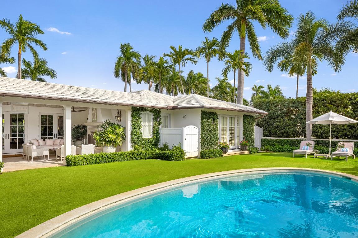 Palm Beach Island oasis. Step inside the chic Palm Beach Bermuda style home to discover a sun-filled, one-story layout where soaring ceilings and elegant finishes create a sense of airy sophistication. The expansive living room, with three sets of double doors, opens seamlessly to a beautiful loggia, blurring the line between indoors and out and setting the stage for effortless entertaining. Beautiful chef's kitchen with breakfast bar. A cozy den with fireplace and an inviting sitting/media room offer relaxing spaces to unwind in. Outside, a pristine loggia with a vaulted ceiling and fireplace invites al fresco dining.  The lush, tropical backyard features a sparkling pool and outdoor shower, creating a private resort-like retreat. Perfectly positioned on the desirable South side of the road in Palm Beach's sought-after North End, this bright, sophisticated home captures the essence of relaxed island luxury.