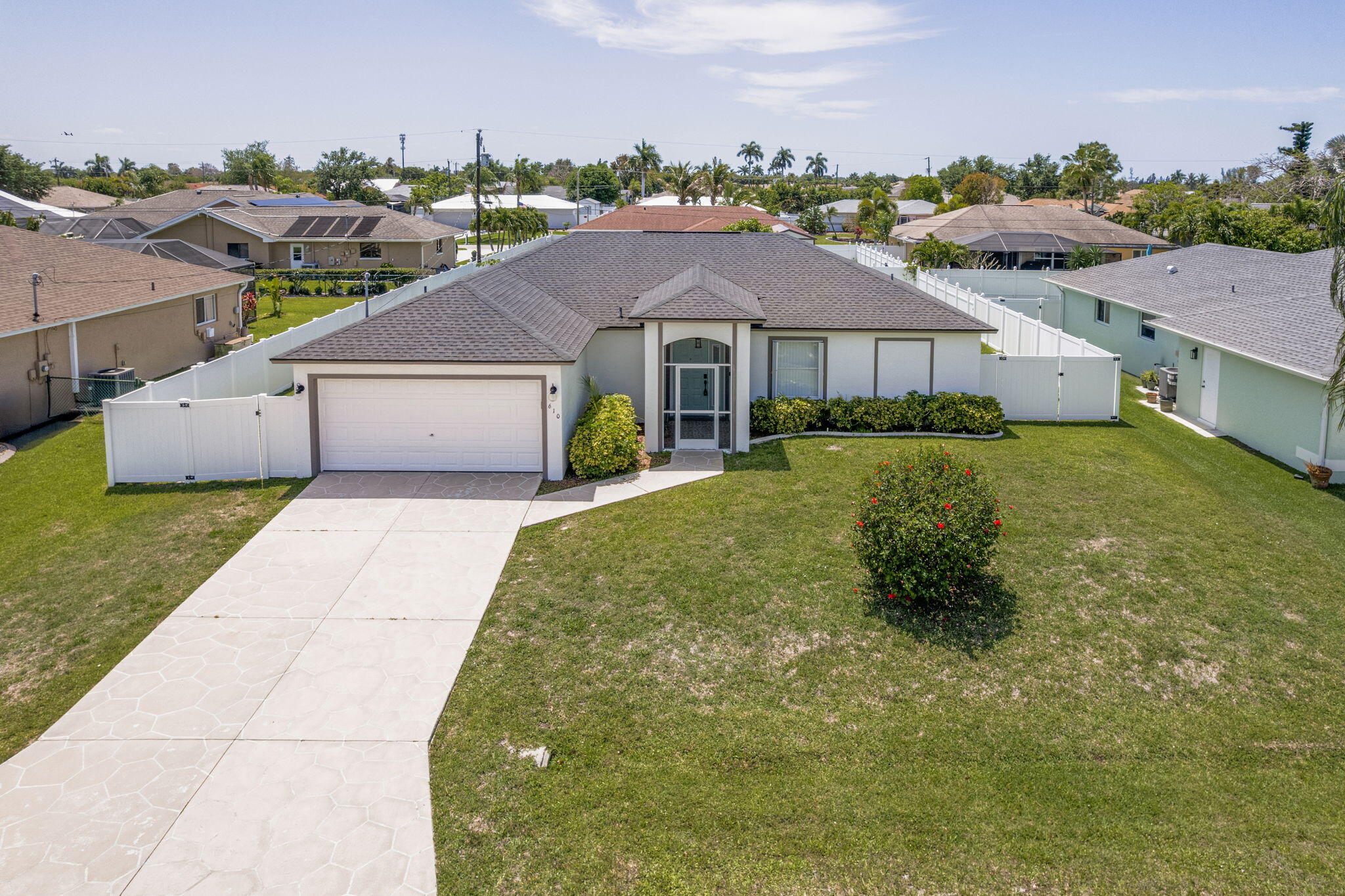 Beautifully updated home in desirable SE Cape Coral w/NO HOA! Rebuilt after Hurricane Ian and featuring major upgrades including a new roof, new AC, new LVT flooring, and new carpet in bedrooms.  The interior offers 2 fully renovated bathrooms, an upgraded laundry room w/cabinets and sink, and a modern kitchen with Cambria quartz countertops (lifetime warranty), under-cabinet lighting, and a fast-cooking stovetop. Additional features include new washer and dryer, dimmable lighting, accordion hurricane shutters & more!  Enjoy a fully fenced, spacious yard with fruit trees and room for a future pool, plus a tiled lanai perfect for relaxing or entertaining. Located in a quiet neighborhood near the police department, with easy access to shopping. Motivated seller! 220V outlet in the backyard