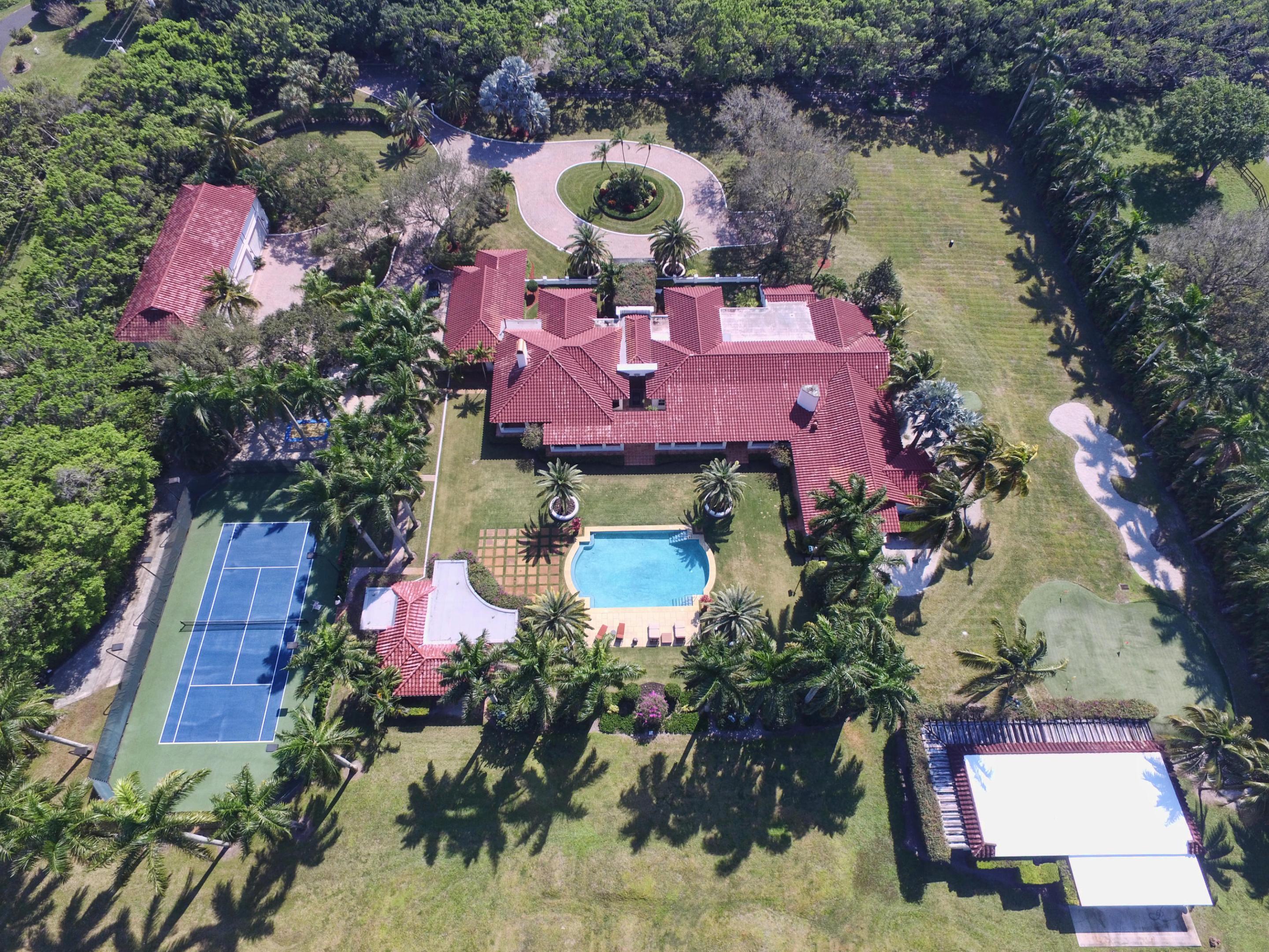 Welcome Home to your tranquil and serene piece of paradise. Upon entering the grounds through private gates, take in the lush and tropical landscape spanning over 5 acres, all leading up to a beautiful 12,000+ sq/ft estate with a 9.5 car garage. The main house encompasses all things luxury with 6 bedrooms, a gourmet kitchen, formal living room & dining room and library. The unique appointments throughout include custom woodwork, a fireplace, wet bar, hard wood and tile flooring. While transitioning to the outdoors, it becomes the perfect getaway for relaxation or entertainment. Enjoy the expansive wrap around veranda overlooking the resort style pool or start a friendly competition on the tennis court and 3 par golf hole. With 2 guest houses, a barn, horse trail, outdoor kitchen and dirt bike track, the possibilities are endless. Live the Florida lifestyle and enjoy your private Horseshoe Acres sanctuary in the city of Boca Raton.