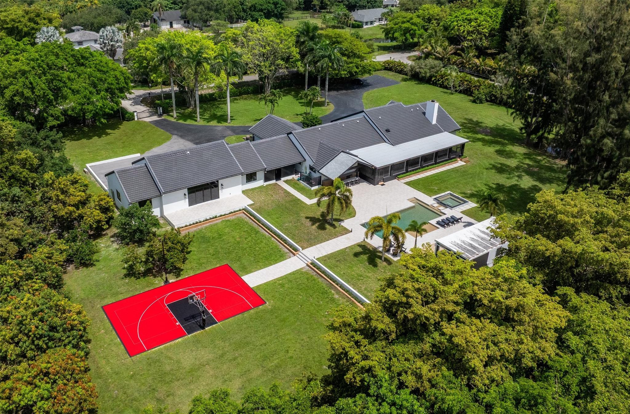 Welcome to an elegant sanctuary where design, privacy, and lifestyle unite in perfect harmony. Set on nearly 3 acres, this fully renovated estate—styled with Restoration Hardware finishes—features 5 bedrooms, 4.5 baths, and a flowing open-concept layout. Extensive upgrades include new roofing, full rewire with LED and Cat5/6, whole-home audio, a custom home theater, smart gate system, new kitchen and baths, decorative ceilings, and 4,000 SF of pavers. Outdoors, enjoy a resort-style pool, basketball court, two outdoor bars with pergolas, lush landscaping, and a 2,100-SF garage. Additional highlights include smart home integration, custom closet systems, enhanced insulation for year-round efficiency, and a serene screened porch. Sophisticated, smart, and truly turnkey.