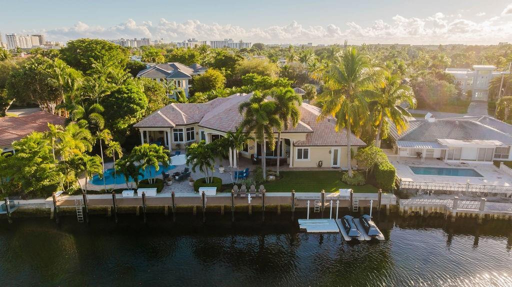 Built in 2000, this custom one-story waterfront home is just seven homes from the Intracoastal, minutes to Hillsboro Inlet. Situated on an oversized lot with 120’ of deep-water on a wide canal and an updated seawall, it’s ideal for yacht owners. The renovated 3,561 SF living / 5,207 SF total residence offers 4 bedrooms plus an office, 3.5 baths, 17’ volume ceilings, and a 3-car garage. Features include a remodeled chef’s kitchen, updated primary bath, marble floors in living areas, wood-look porcelain tile in bedrooms, wet bar with wine ref., natural gas, and a striking stone fireplace. Outdoor amenities include two covered loggias, heated/salt water pool, summer kitchen, and expansive entertaining areas. Impact glass, whole-house generator, and a premier waterfront location!